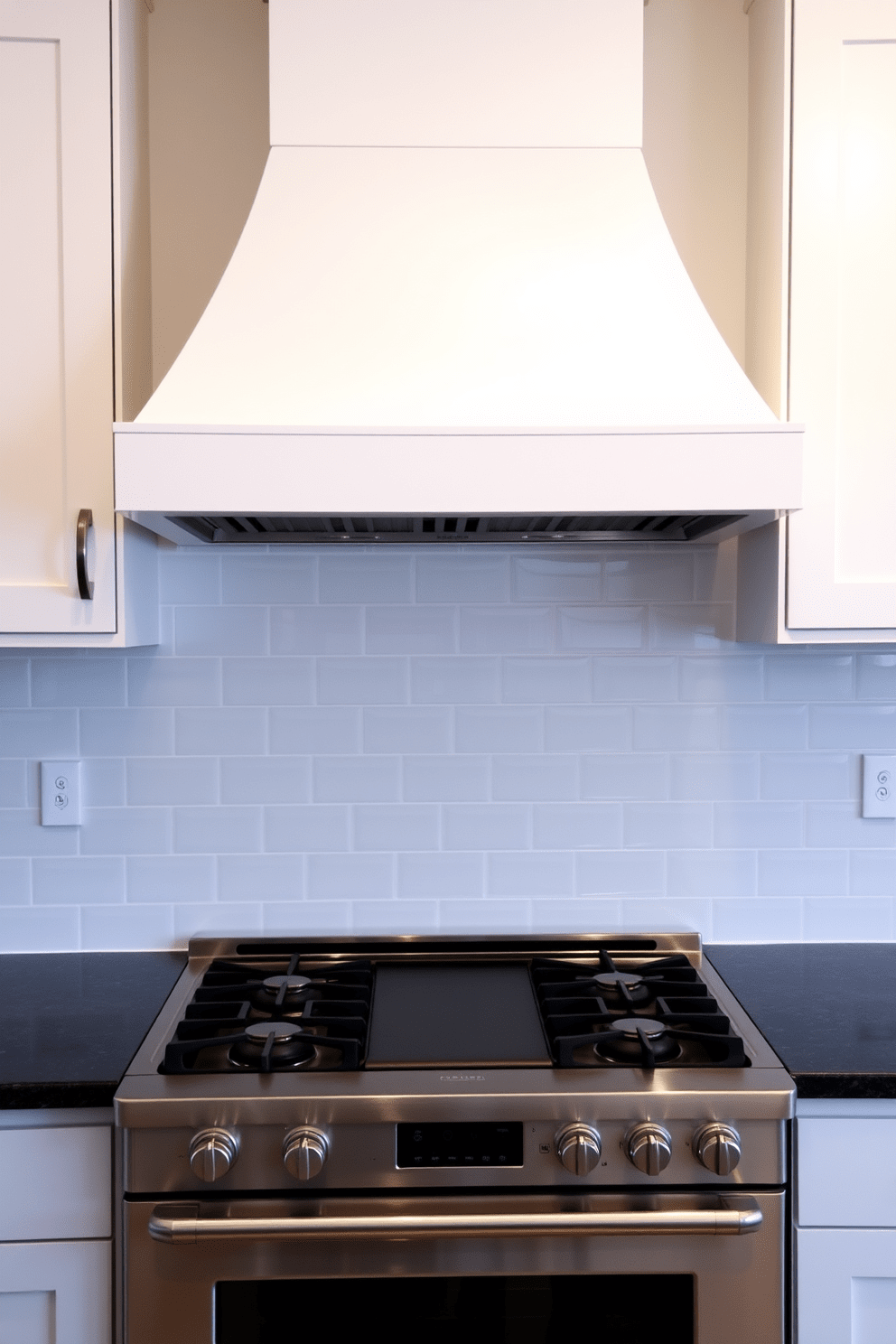 A sleek kitchen hood with a hidden vent seamlessly integrates into the cabinetry, creating a clean and modern aesthetic. The hood features a minimalist design in a matte white finish, complementing the surrounding cabinetry and providing an unobtrusive focal point. Beneath the hood, a spacious cooking area is equipped with high-end stainless steel appliances, including a gas range and double ovens. The backsplash is adorned with elegant subway tiles in a soft gray hue, enhancing the overall sophistication of the kitchen design.