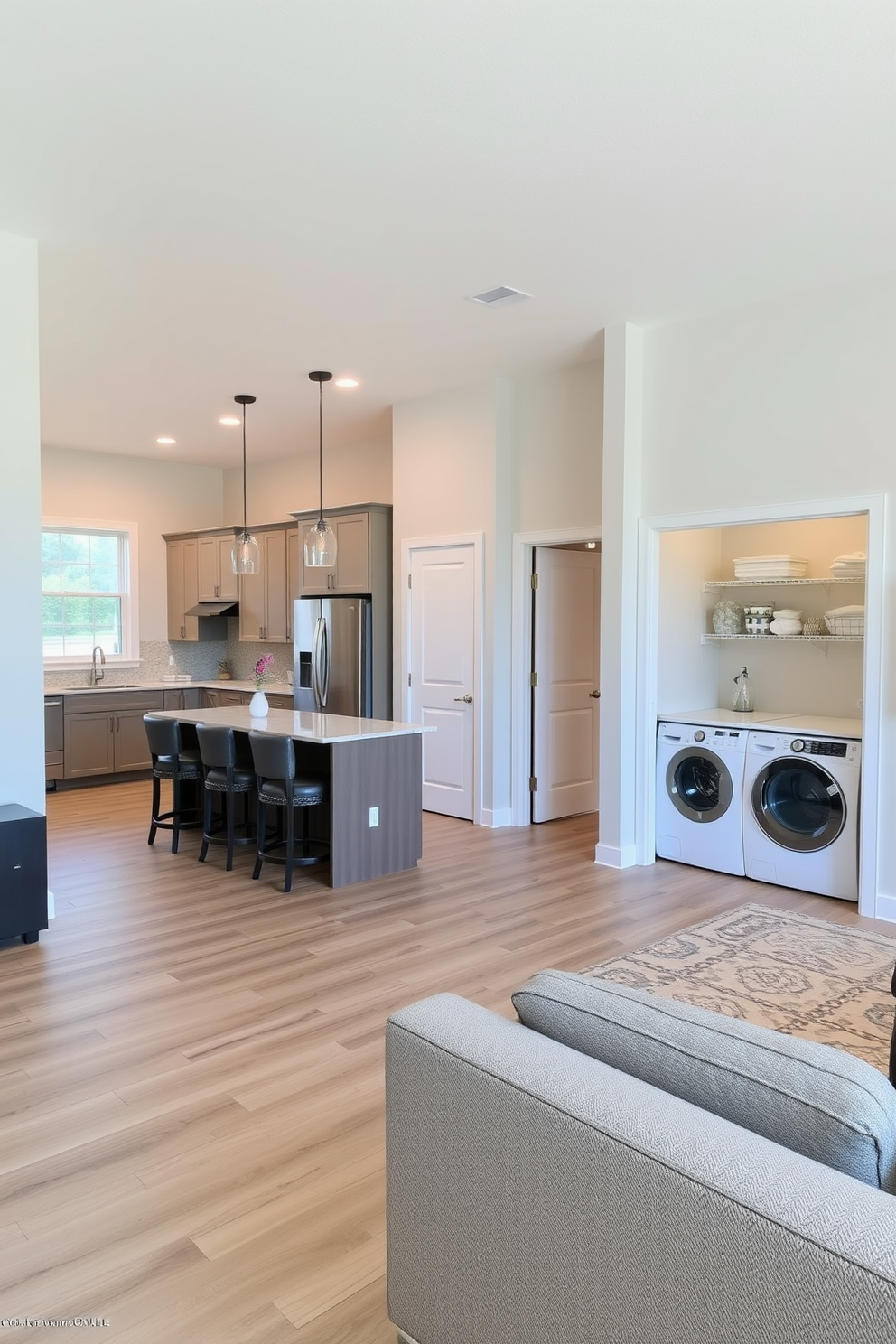 Open floor plan that seamlessly connects the kitchen and laundry room creating a spacious and inviting atmosphere. The kitchen features an island with bar seating and sleek cabinetry, while the laundry room includes organized storage solutions and modern appliances for efficiency.