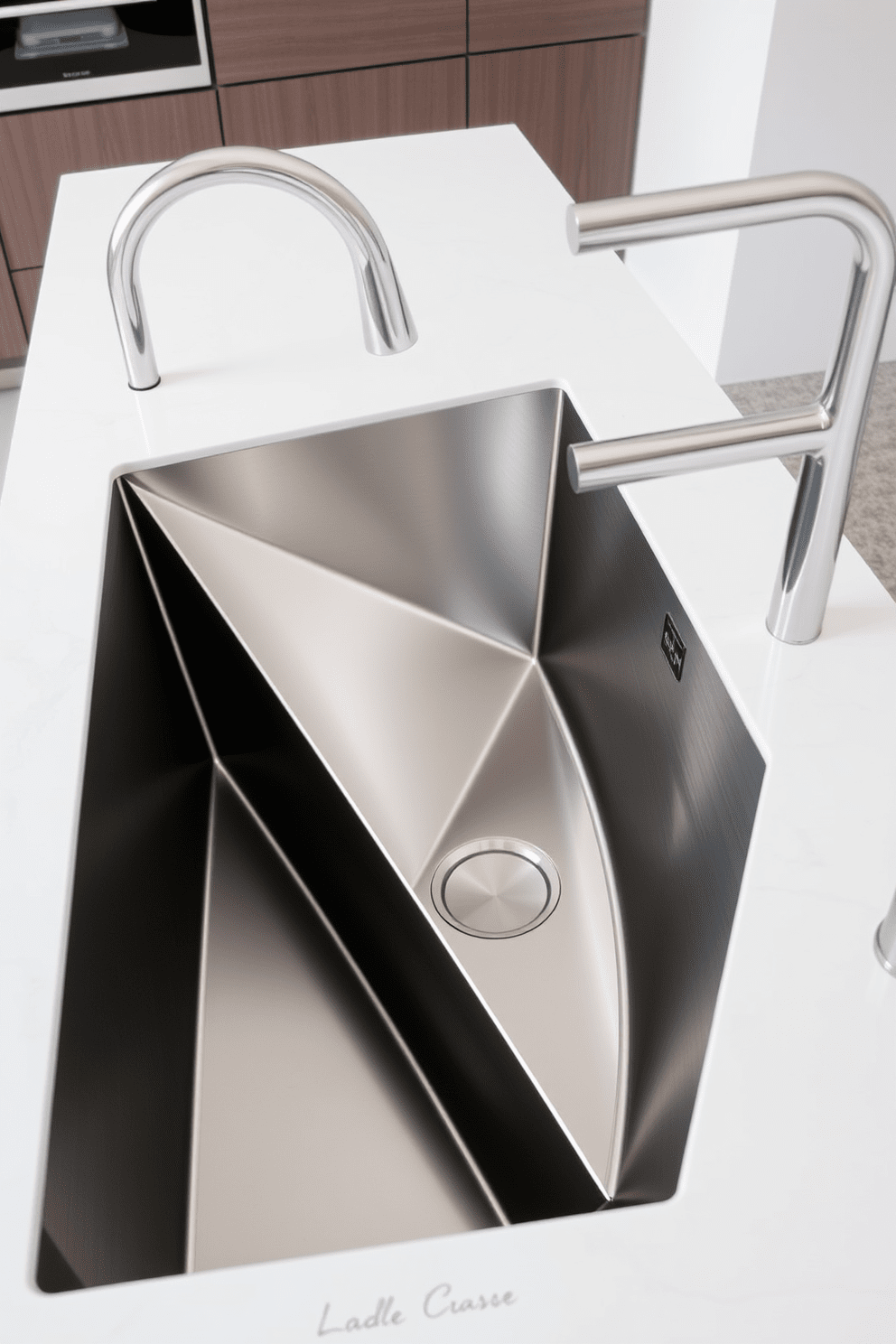 A modern kitchen sink featuring sleek geometric shapes. The sink is crafted from stainless steel with sharp angles and a minimalist design, seamlessly integrated into a stylish countertop.