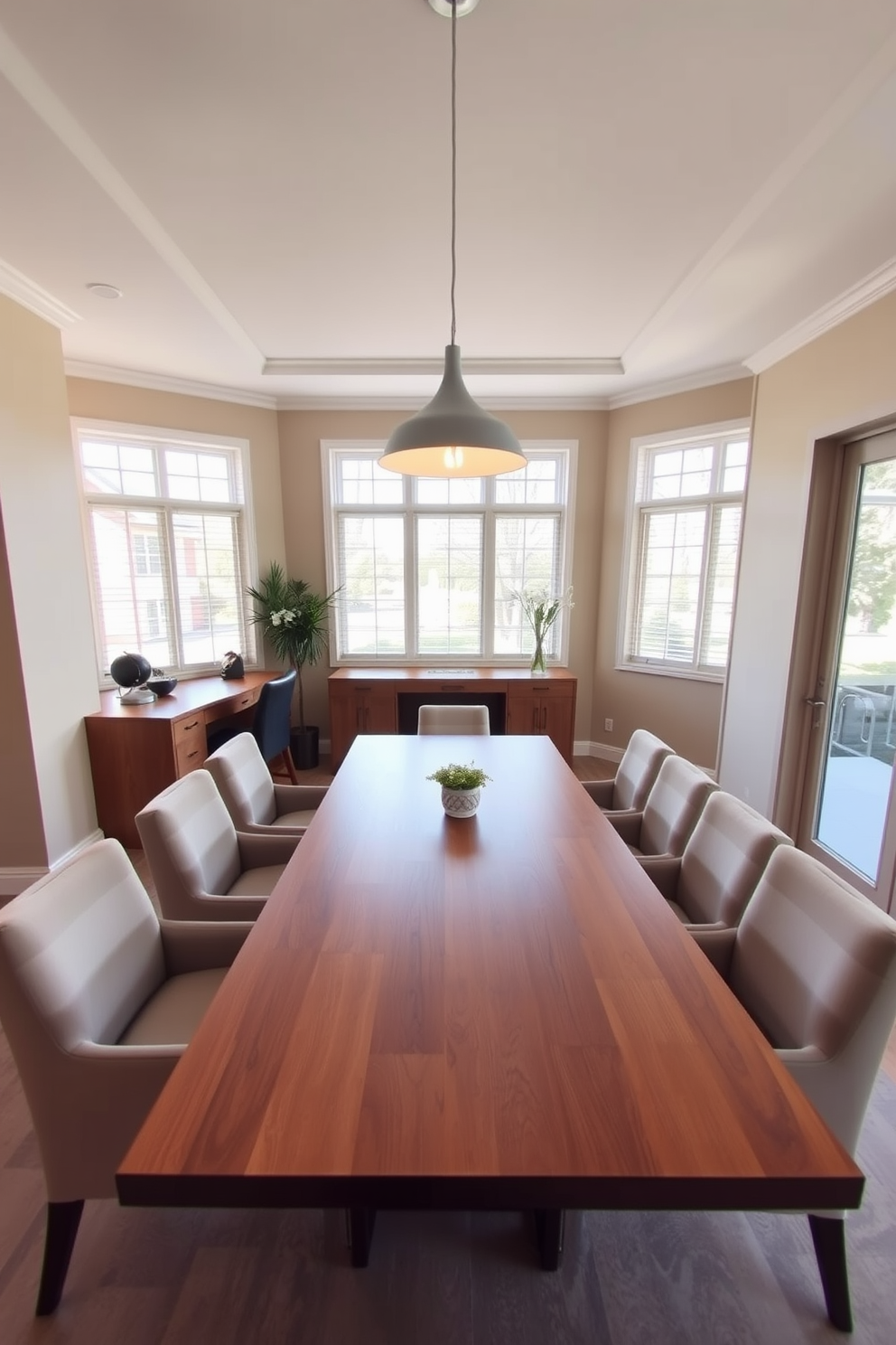 A stylish L-shaped dining room featuring a sleek wooden table surrounded by upholstered chairs. In one corner, a small desk is integrated into the design, providing dual functionality for dining and work. The walls are painted in a soft beige, creating a warm and inviting atmosphere. Large windows allow natural light to flood the space, highlighting a contemporary pendant light hanging above the dining table.