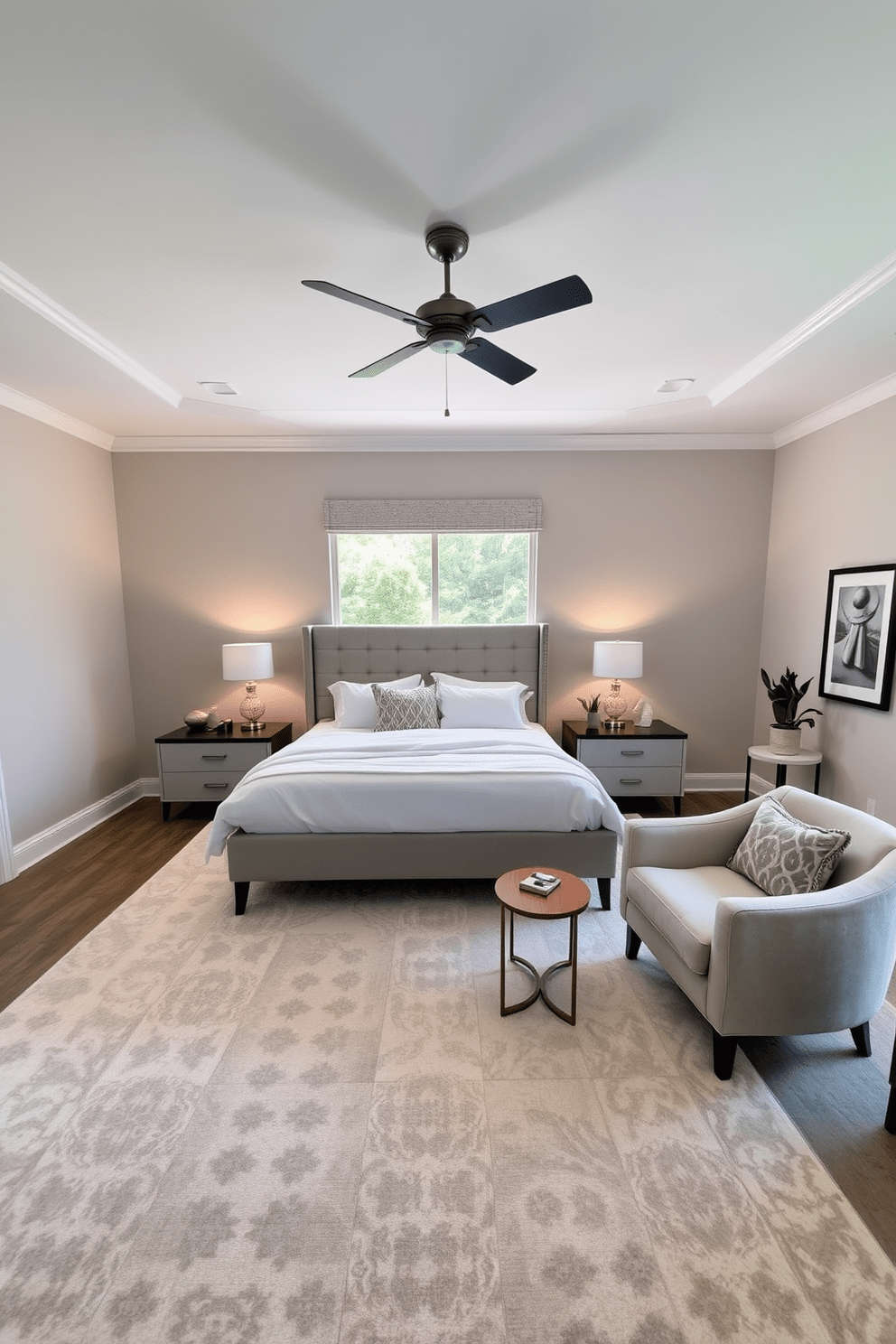 A spacious bedroom featuring a king-sized bed with a plush upholstered headboard and crisp white linens. Flanking the bed are two modern nightstands with stylish lamps that provide a warm glow. The walls are painted in a soft gray, creating a calming atmosphere, while a large area rug adds texture and warmth underfoot. A cozy seating area with a pair of armchairs and a small side table is positioned near a window that allows natural light to fill the room. A ceiling fan hangs from the ceiling, providing both airflow and a touch of contemporary style. Decorative elements such as framed artwork and potted plants enhance the inviting ambiance of the space.