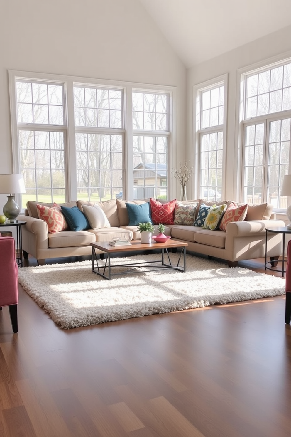 A cozy sectional sofa is positioned in the center of a spacious family room. The sofa is adorned with vibrant throw pillows in various colors and patterns, creating a warm and inviting atmosphere. Surrounding the sectional, a plush area rug adds texture and comfort underfoot. Large windows allow natural light to flood the room, highlighting the soft neutral tones of the walls and furniture.