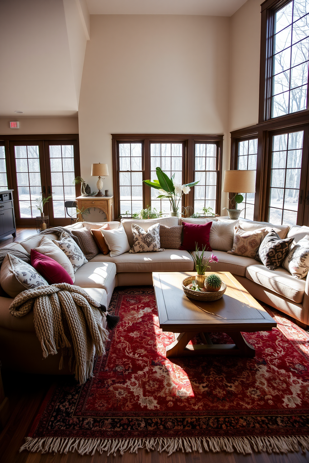 A large family room filled with a cozy mix of textures featuring plush cushions and soft throws. The space includes a spacious sectional sofa adorned with a variety of patterned and solid-colored cushions, complemented by a chunky knit throw draped over the armrest. Natural light floods the room through oversized windows, highlighting a warm wooden coffee table at the center. A vibrant area rug anchors the seating area, while decorative accents like potted plants and artwork add personality to the design.