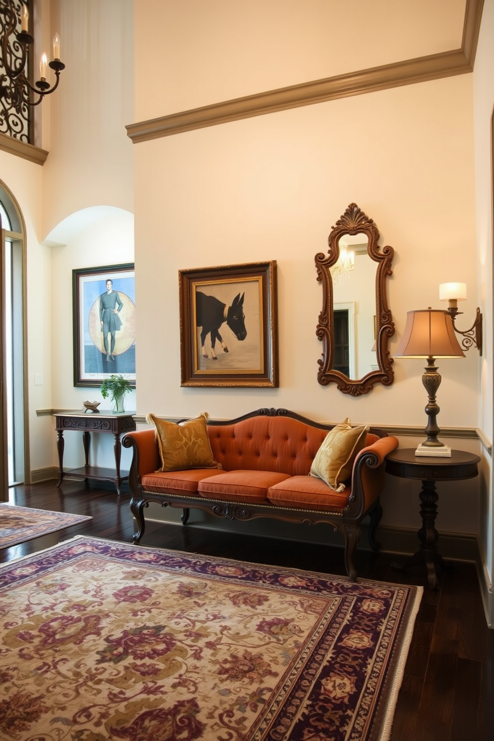 A vintage bench is positioned against the wall of a spacious foyer, adding a classic touch to the entryway. The bench features ornate woodwork and plush upholstery in rich, warm tones that invite guests to sit and relax. The foyer is adorned with elegant lighting fixtures that cast a warm glow over the space. A large area rug in a traditional pattern anchors the room, while framed artwork and decorative mirrors enhance the sophisticated atmosphere.