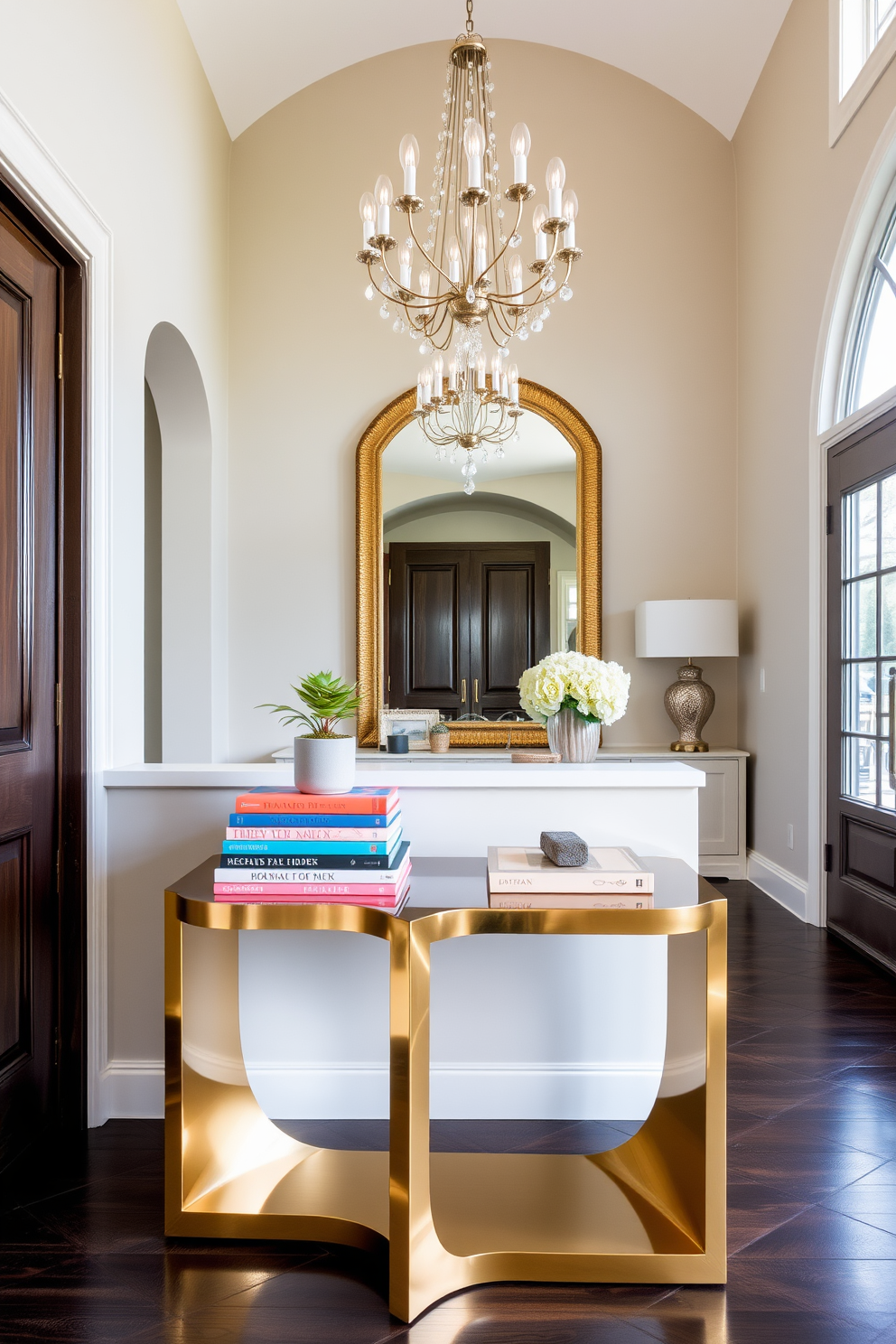 Chic side table with decorative books. The table features a sleek design in a polished gold finish, adorned with a stack of colorful coffee table books and a small potted succulent. Large foyer design ideas. The foyer boasts high ceilings with an elegant chandelier, complemented by a grand console table and a statement mirror that reflects the light beautifully.