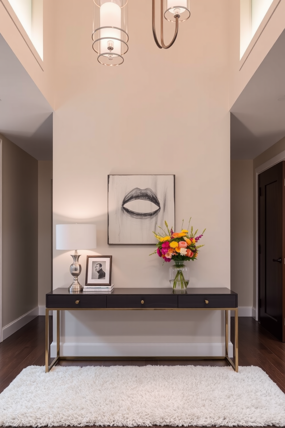 A stylish console table is placed against a wall in a spacious foyer. The table is adorned with decorative accents such as a sleek lamp, a few art books, and a vibrant vase filled with fresh flowers. The foyer features a high ceiling with elegant lighting fixtures that enhance the atmosphere. The walls are painted in a soft neutral tone, complemented by a plush area rug beneath the console table.