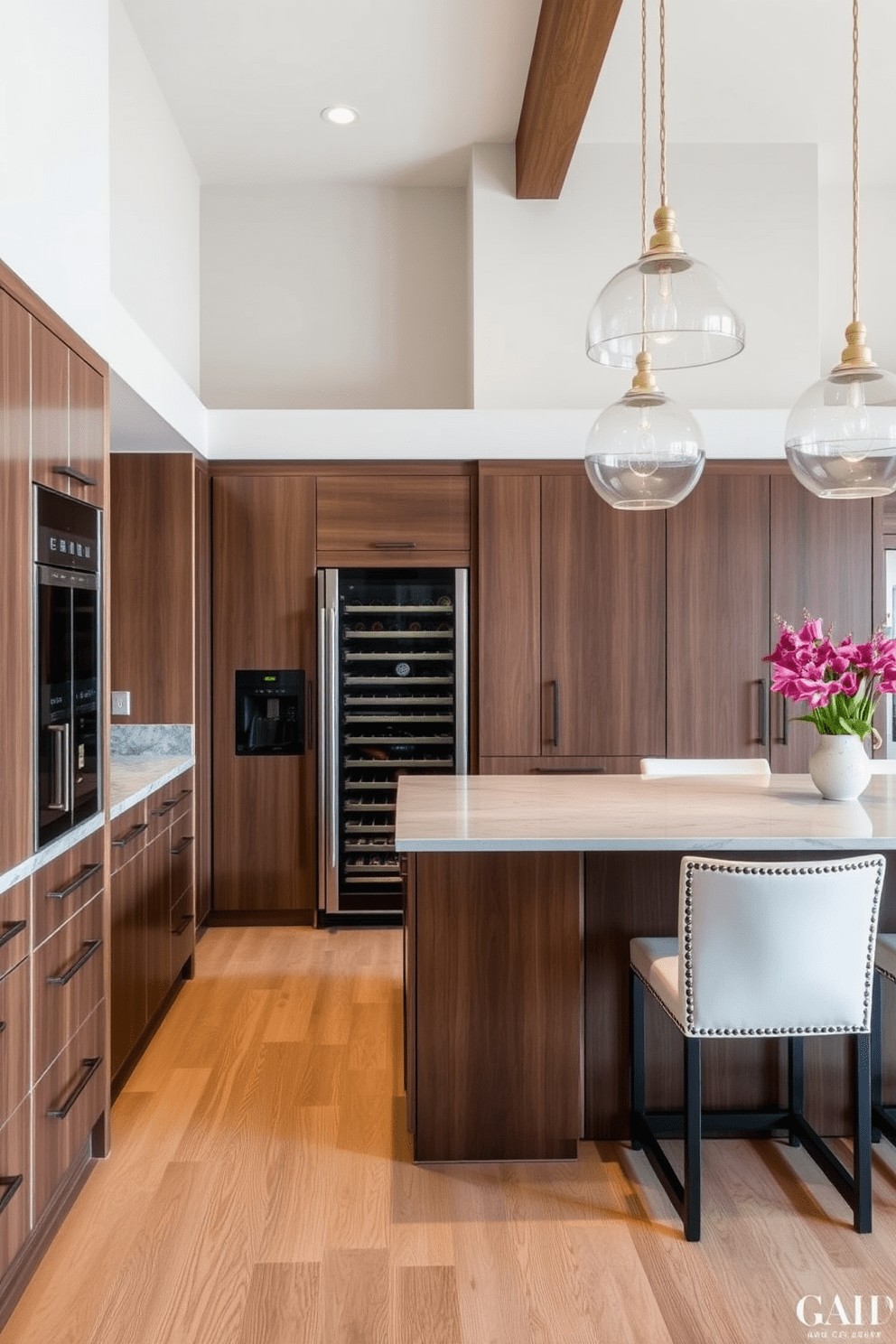 A large kitchen designed for entertaining features a built-in wine fridge seamlessly integrated into the cabinetry. The space includes an expansive island with bar seating and elegant pendant lighting overhead.