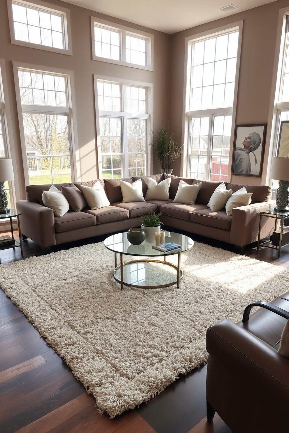 Cozy sectional sofa adorned with oversized pillows in a spacious living room. The room features large windows allowing natural light to flood in, complemented by warm, neutral tones on the walls. A plush area rug anchors the seating arrangement, adding texture and comfort. Stylish side tables and a modern coffee table complete the inviting atmosphere, while decorative art pieces adorn the walls.