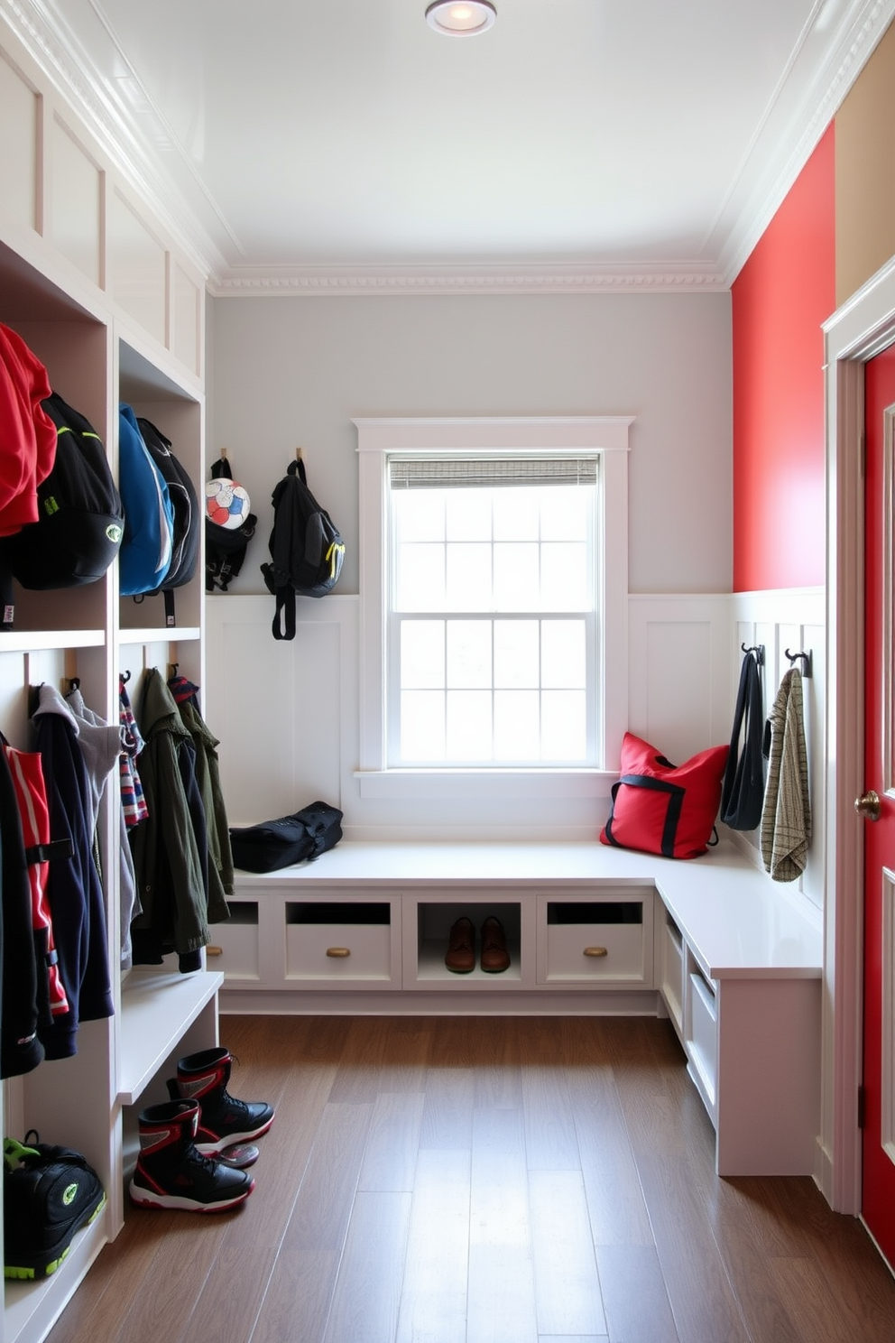 A spacious mudroom designed for optimal organization of sports equipment and outdoor gear. The area features built-in cubbies and hooks for jackets and bags, with durable flooring that can withstand heavy use. Natural light floods the space through large windows, illuminating a bench for seating and storage below. The walls are painted in a light, airy color, complemented by a vibrant accent wall that adds character to the room.