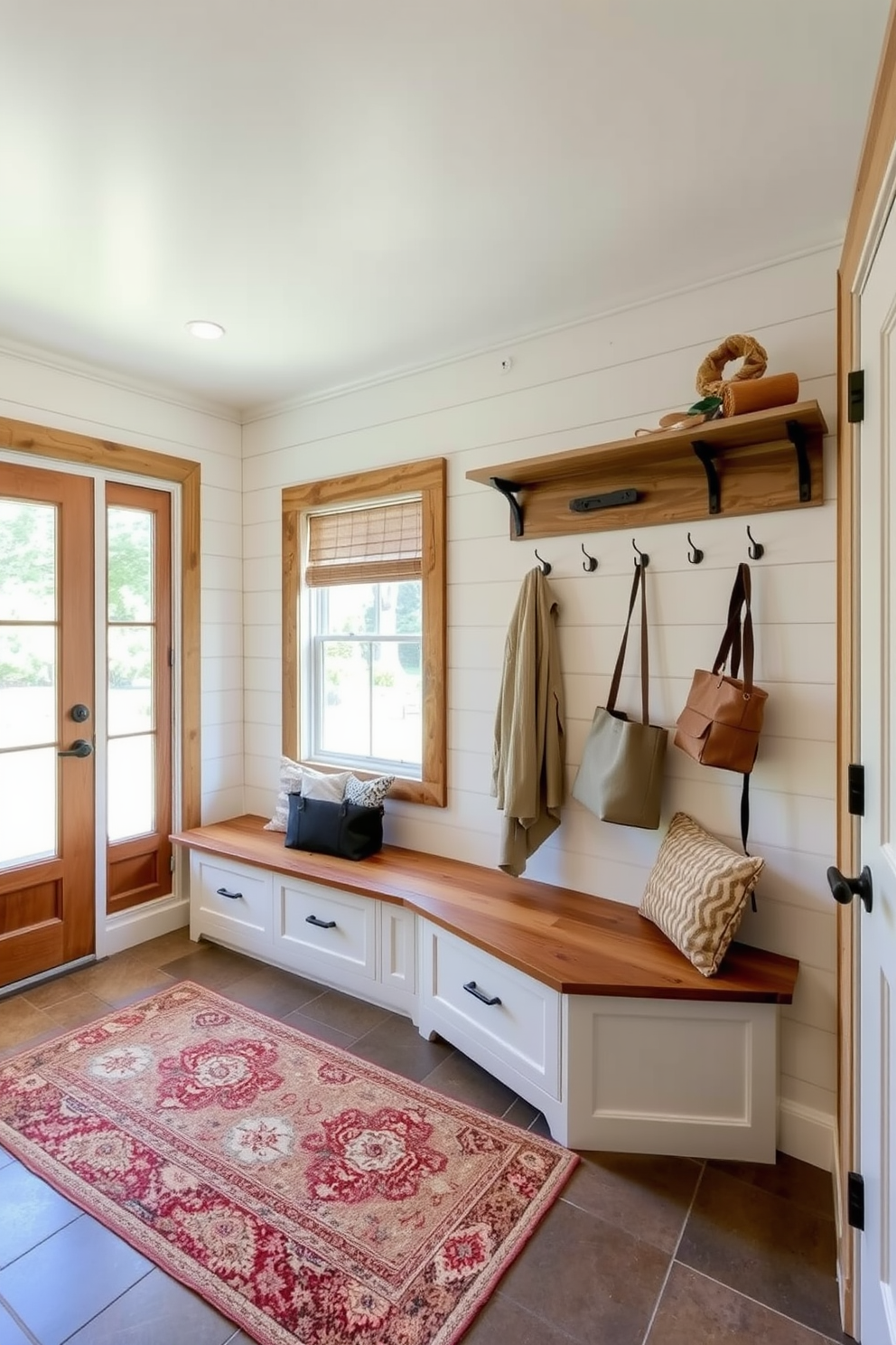 A welcoming mudroom designed in farmhouse style features reclaimed wood accents throughout. The space includes a spacious bench with built-in storage underneath and hooks for hanging coats and bags. Natural light streams in through a large window, illuminating the shiplap walls painted in a soft white hue. A rustic area rug in warm tones adds comfort and charm to the durable tile floor.