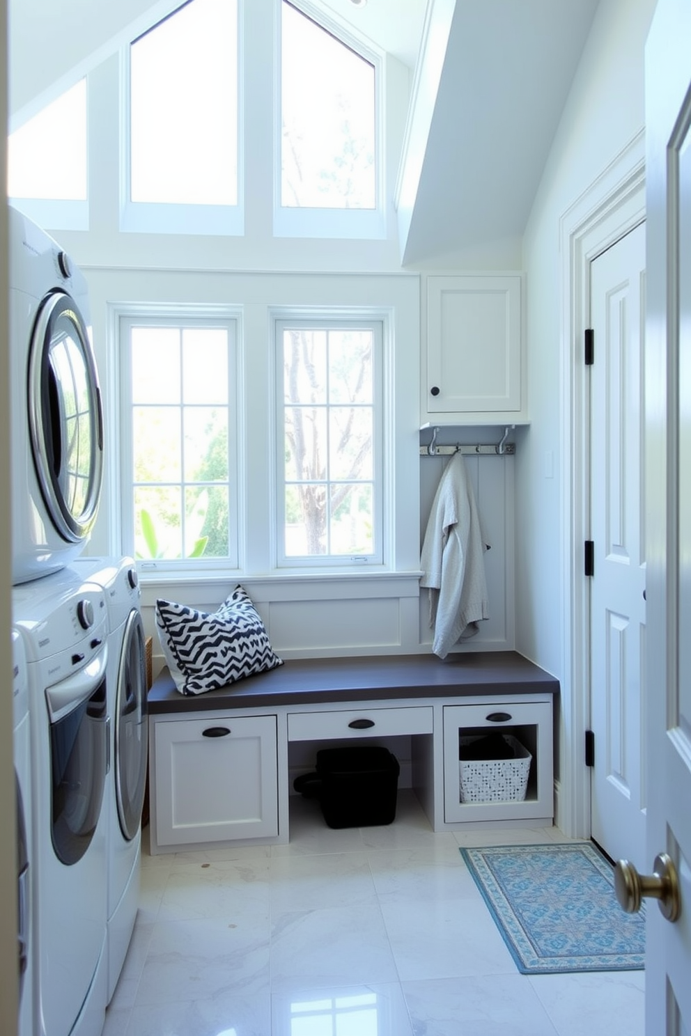 A bright and airy laundry mudroom with large windows allowing natural light to flood the space. The room features a built-in bench with storage underneath, surrounded by soft pastel-colored cabinetry and a stylish backsplash.