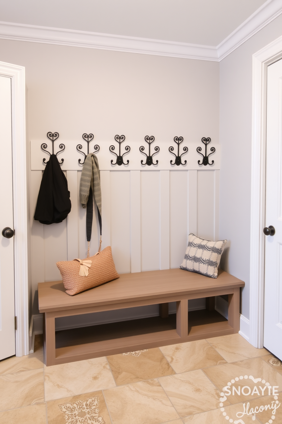 A functional mudroom featuring decorative hooks for stylish organization. The walls are painted in a soft gray, and the flooring is a durable tile that can withstand heavy foot traffic. The decorative hooks are arranged in an eye-catching pattern, providing ample space for coats and bags. A built-in bench with storage underneath complements the design, adding both style and practicality.