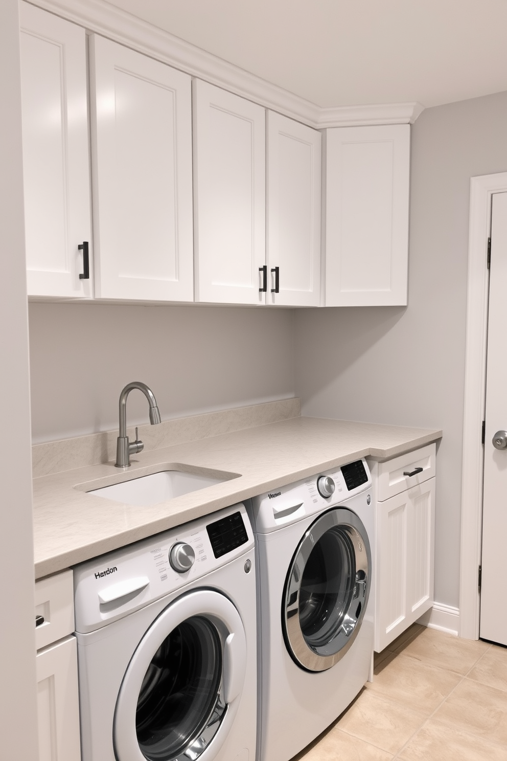 A functional laundry room in the basement features a spacious utility sink positioned on a sturdy countertop. The room is equipped with ample storage cabinets above and below the counter, painted in a soft white hue to enhance brightness. The walls are adorned with light gray paint, creating a clean and modern look. A washer and dryer are neatly placed side by side, with a stylish backsplash that adds a touch of elegance to the space.