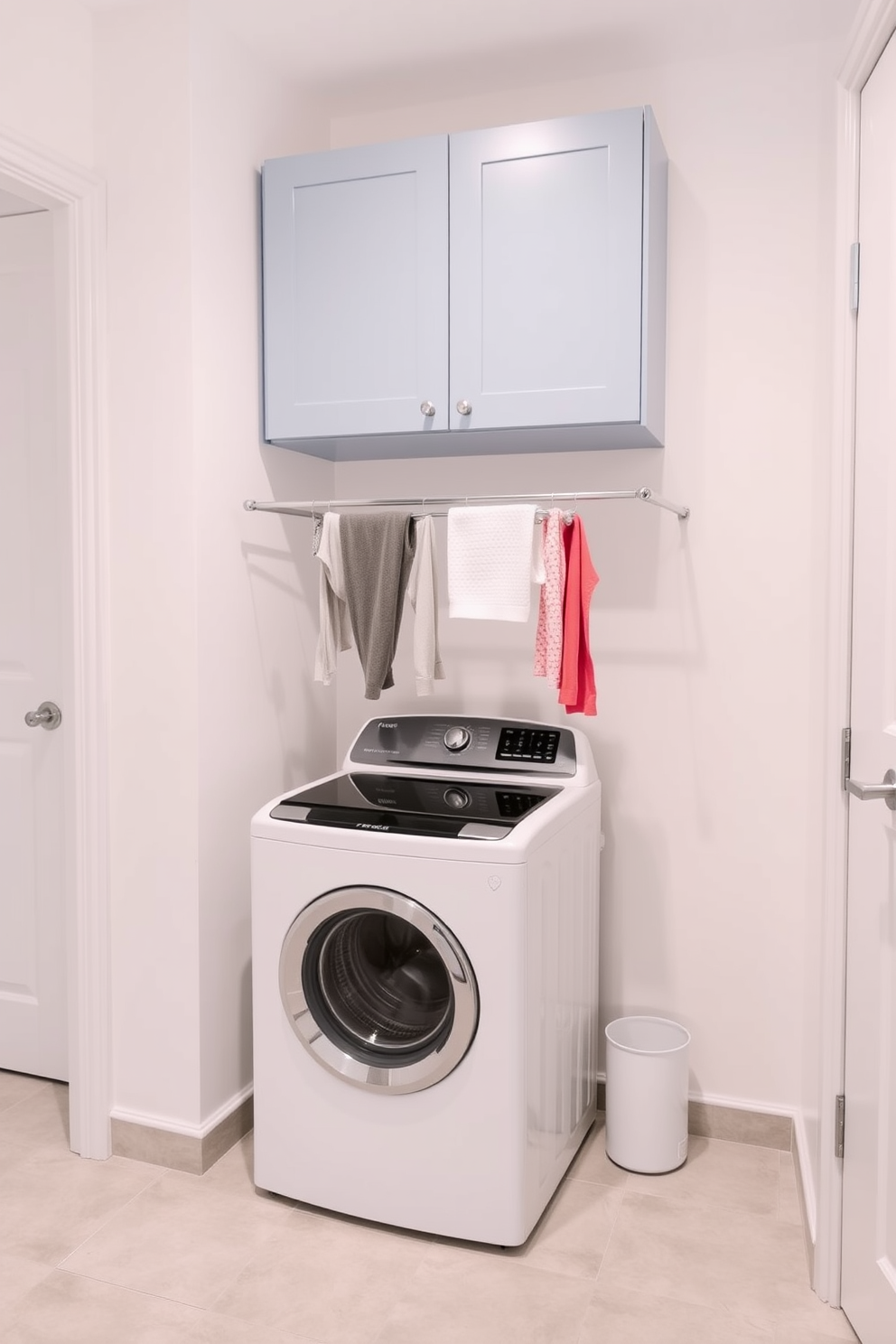 A modern laundry room featuring a top-loading washer positioned against a clean white wall. Above the washer, a sleek drying rack is installed, providing ample space for hanging clothes to dry. The floor is adorned with light gray tiles that complement the bright atmosphere. Storage cabinets in a soft blue hue are mounted above the washer, offering practical organization for laundry essentials.