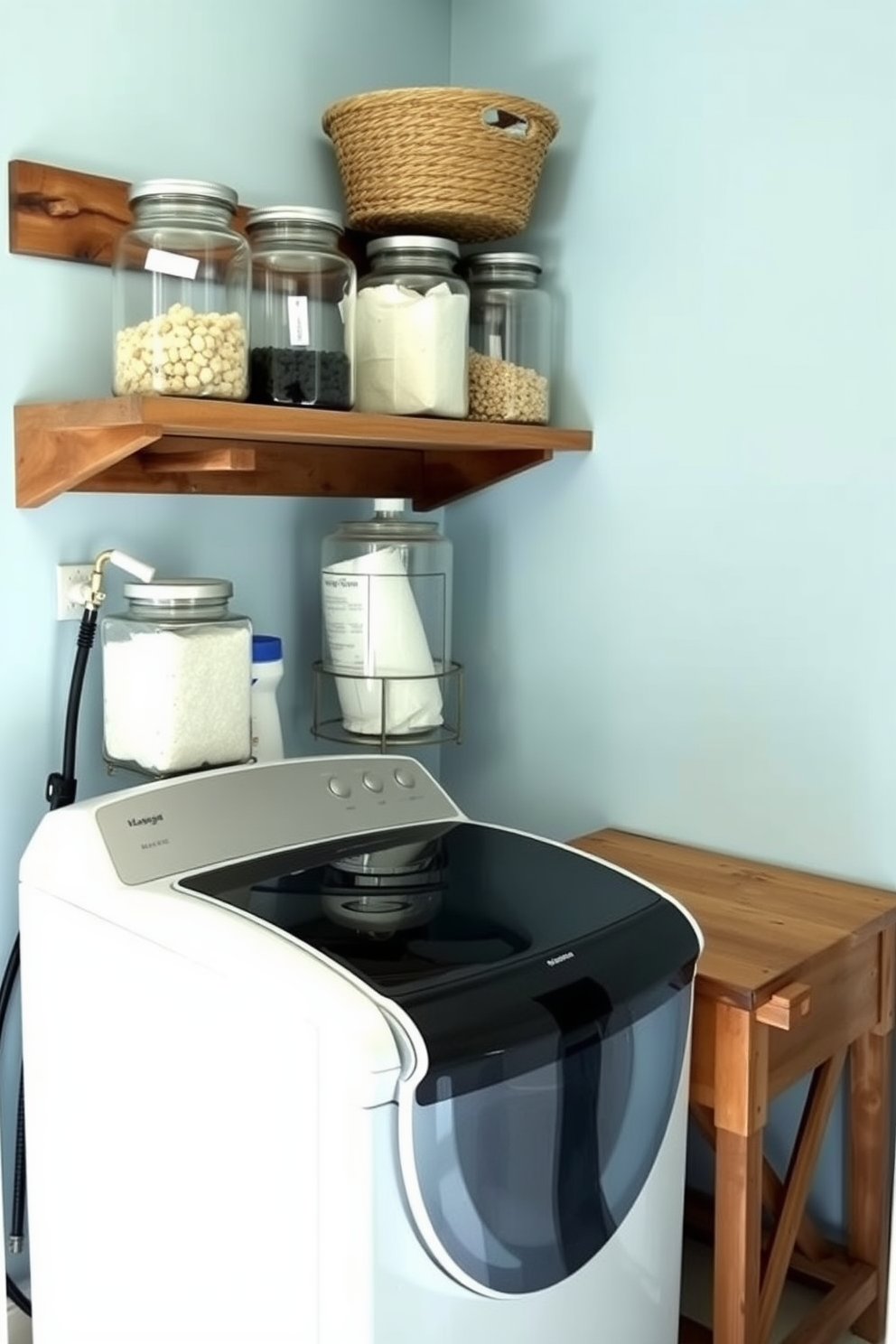 A stylish laundry room featuring a top loading washer is designed for both functionality and aesthetics. Glass jars neatly store laundry supplies, adding a touch of elegance while keeping everything organized. The room is painted in a soft blue hue, creating a calm atmosphere. A wooden shelf above the washer holds the glass jars, complemented by a rustic wooden folding table for added convenience.