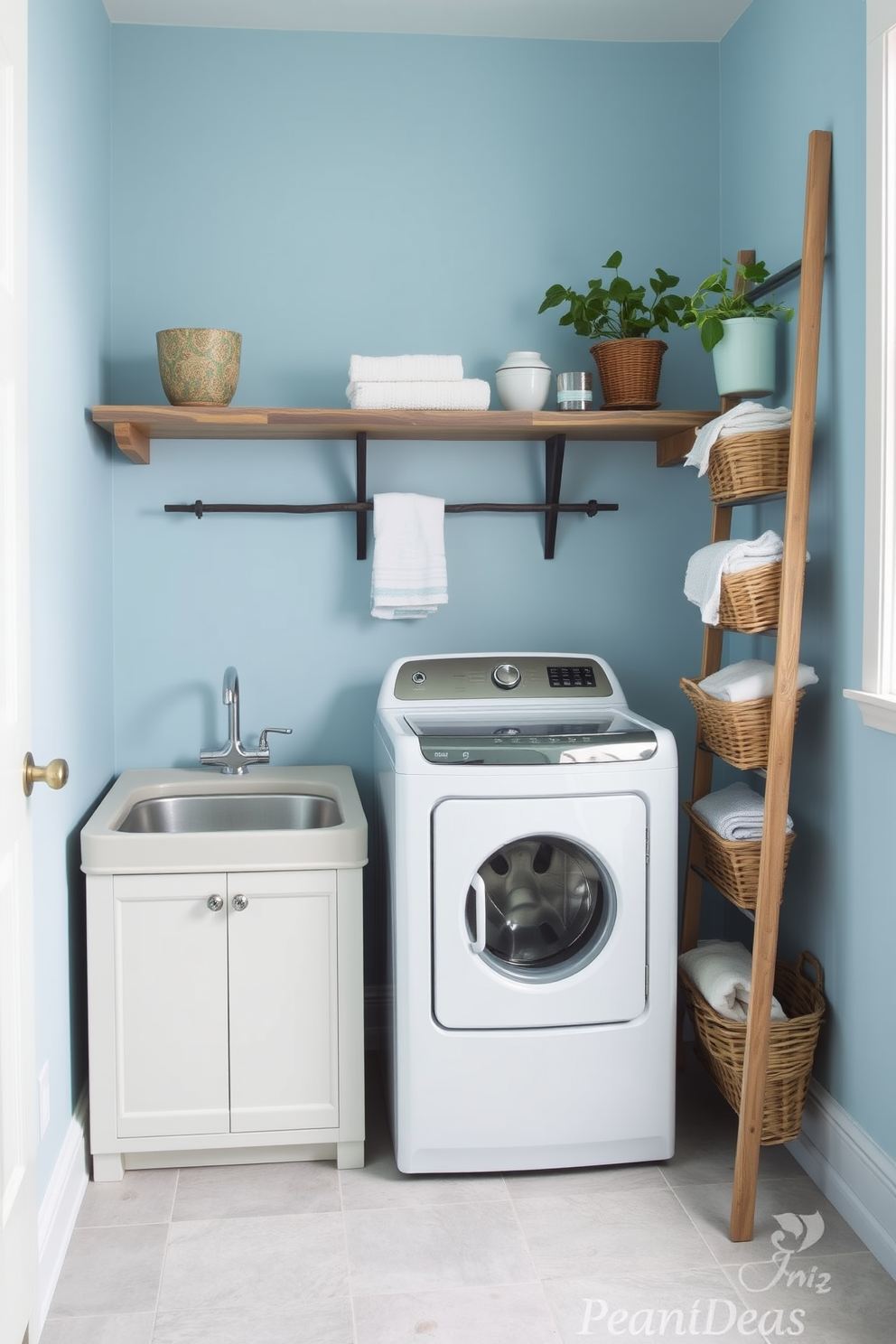 A charming laundry room featuring a top-loading washer positioned against a backdrop of soft blue walls. A vintage wooden ladder leans against the wall, adorned with neatly folded towels and decorative baskets for added storage. The floor is covered in light gray tiles, creating a clean and inviting atmosphere. A rustic wooden shelf above the washer holds plants and laundry essentials, enhancing the room's cozy appeal.