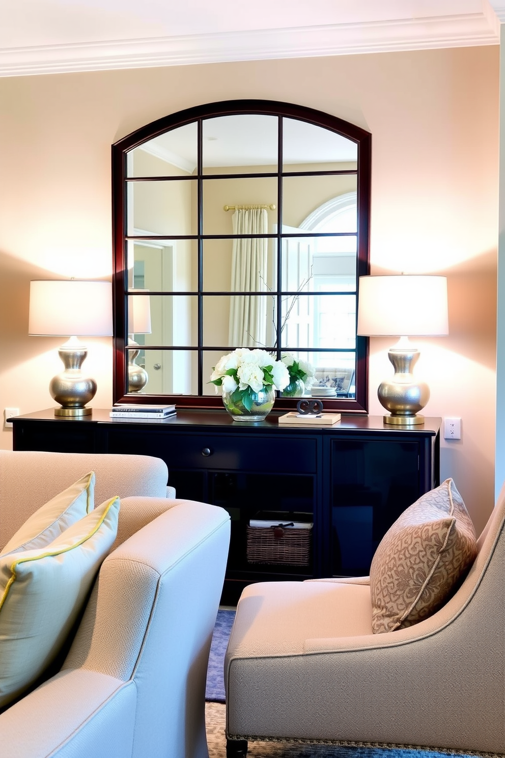 A welcoming living room entryway features soft lighting provided by stylish table lamps placed on either side of a console table. The walls are adorned with a warm neutral paint, and a large mirror reflects the inviting ambiance of the space.