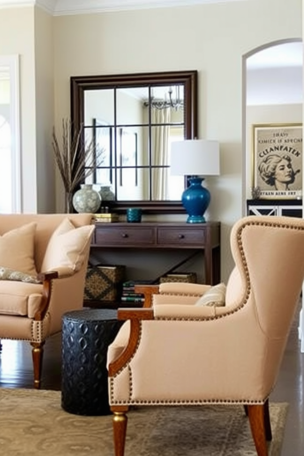 Comfortable accent chairs for seating. The chairs feature soft upholstery in a warm beige tone, with plush cushions and elegant wooden legs that complement the surrounding decor. Living Room Entryway Design Ideas. The entryway showcases a stylish console table adorned with decorative items, while a large mirror reflects the natural light, creating an inviting atmosphere.