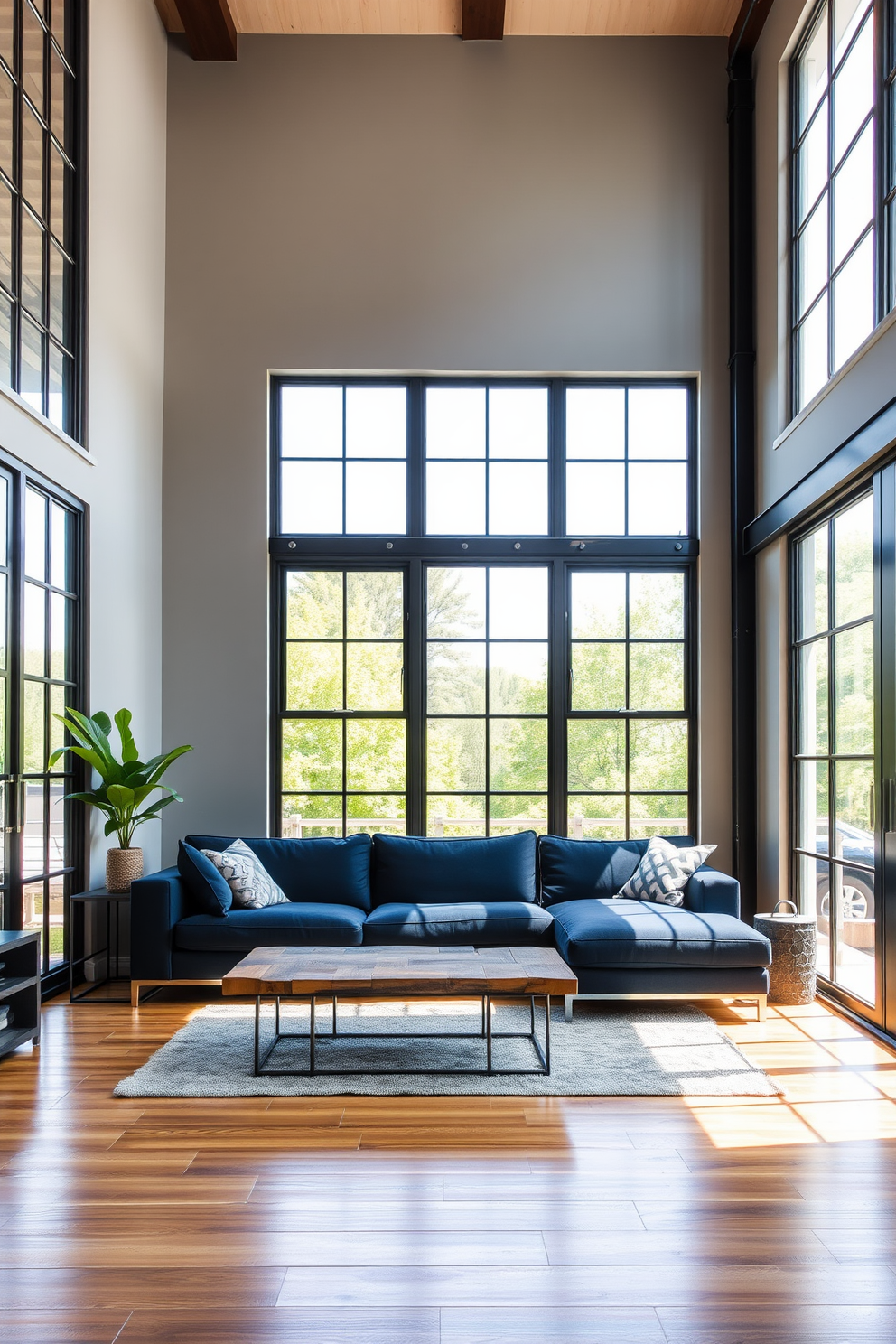 A contemporary living room featuring industrial metal frames that add an urban edge. Large windows with black metal grids allow natural light to flood the space, creating a bright and airy atmosphere. The walls are painted in a soft gray tone, complementing the warm wooden flooring. A plush sectional sofa in deep blue sits opposite a sleek coffee table made of reclaimed wood and metal.