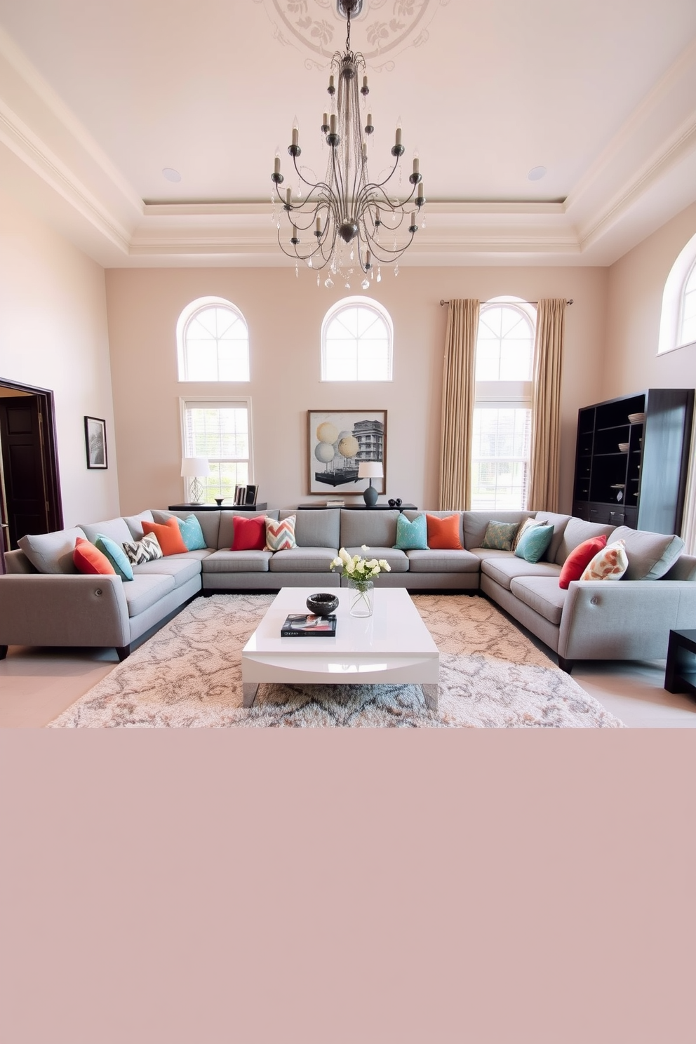 A spacious living room featuring a large sectional sofa in a soft gray fabric, adorned with colorful throw pillows. A sleek coffee table sits in the center, complemented by a plush area rug that adds warmth to the space. The walls are painted in a light beige tone, enhancing the room's airy feel. A statement chandelier hangs from the ceiling, adding a touch of elegance and sophistication to the overall design.