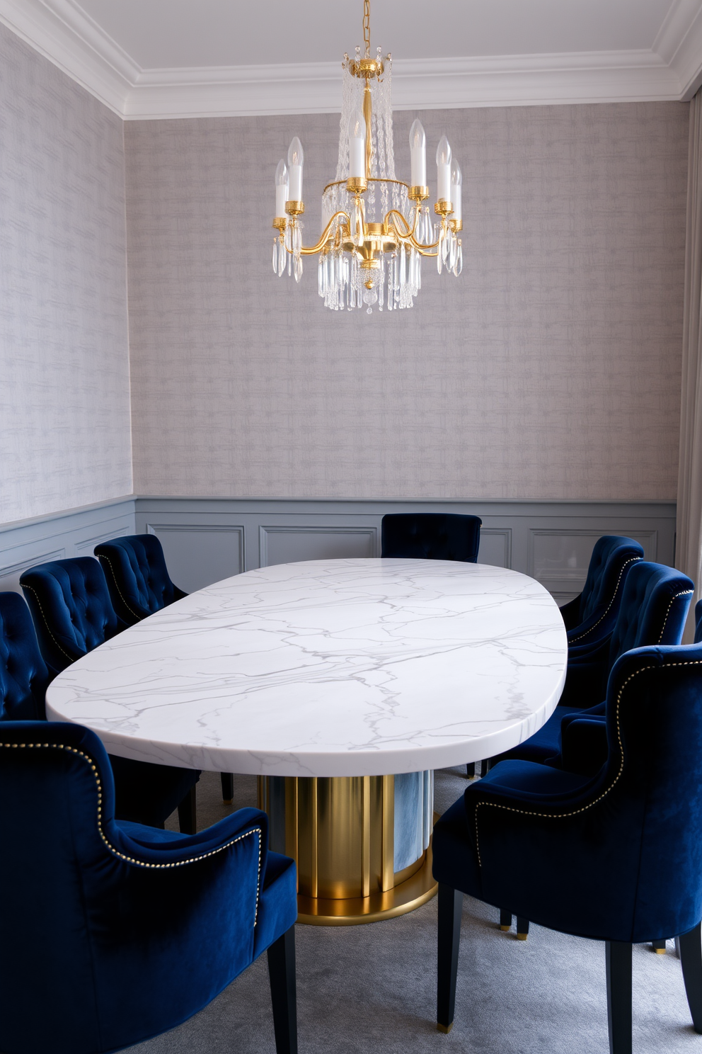 Elegant marble dining table with gold accents. The table is surrounded by plush velvet chairs in a deep navy blue, creating a striking contrast. The walls are adorned with soft gray wallpaper featuring subtle textures. A contemporary chandelier with crystal elements hangs above the table, casting a warm glow over the space.