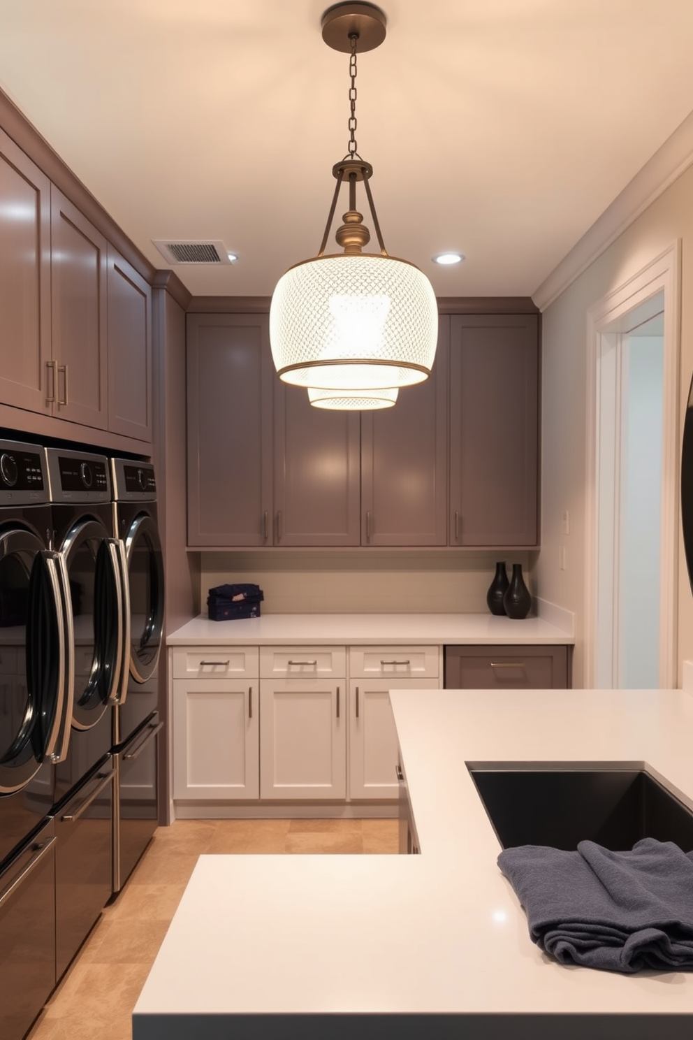 A stylish laundry room featuring elegant pendant lighting that casts a warm glow throughout the space. The room is equipped with high-end appliances, sleek cabinetry, and a spacious countertop for folding clothes.