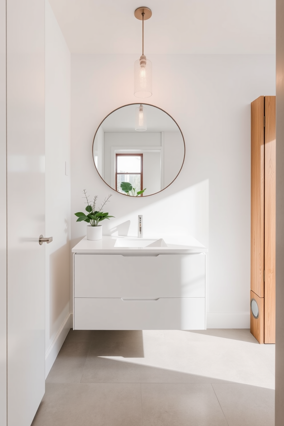 A minimalist luxury powder room features sleek cabinetry with a smooth white finish and a floating vanity. The walls are painted in a soft neutral tone, and a large round mirror hangs above the vanity, reflecting natural light. The flooring consists of large format tiles in a light gray color, creating an open and airy feel. A single elegant pendant light illuminates the space, while a small potted plant adds a touch of greenery.