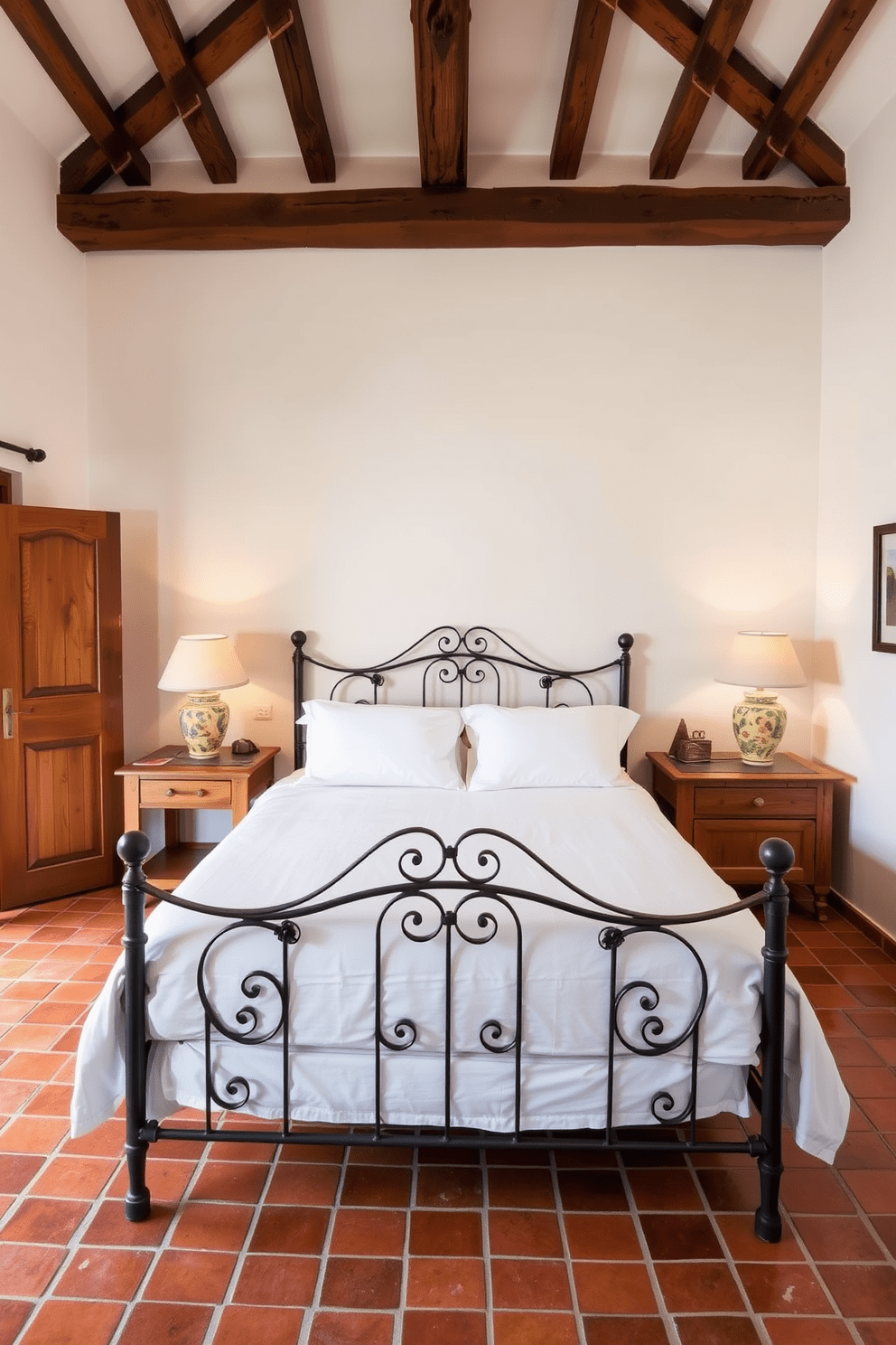 A cozy Mediterranean bedroom featuring warm terracotta tile flooring that adds a rustic charm. The walls are painted in soft white, complemented by wooden beams on the ceiling, creating a welcoming atmosphere. A large wrought iron bed with crisp white linens sits at the center, flanked by rustic wooden nightstands. Decorative ceramic lamps provide soft lighting, enhancing the room's inviting feel.