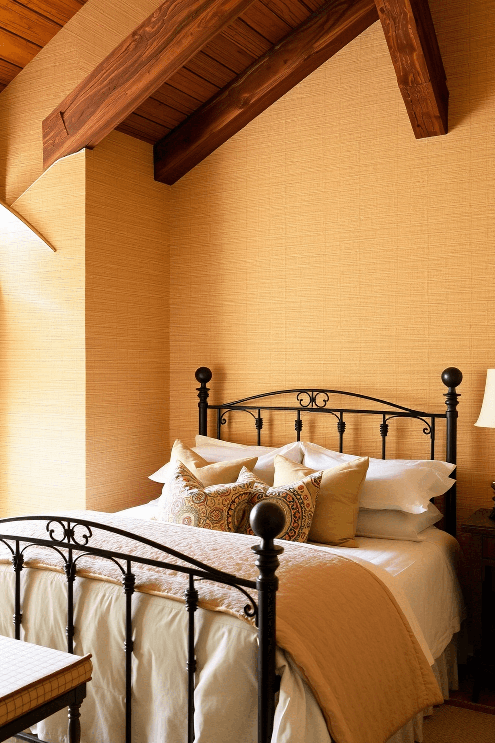 Textured wallpaper adds depth and character to a Mediterranean bedroom. The walls are adorned with a soft, patterned wallpaper in warm, earthy tones, complementing the rustic wooden beams overhead. A plush bed with a wrought iron frame sits against the wall, draped in light linens that evoke a breezy coastal feel. Decorative pillows in vibrant colors and patterns enhance the inviting atmosphere of the space.