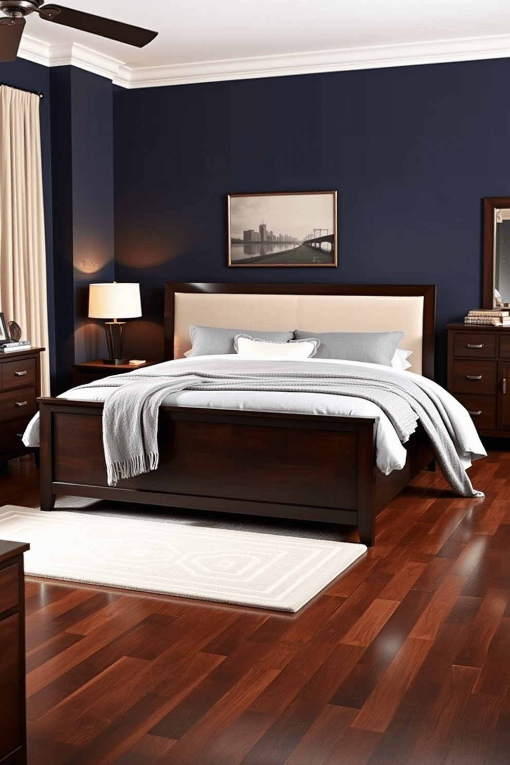 A sophisticated men's bedroom featuring dark wood furniture pieces. The bed is a king size with a dark wood frame and a plush upholstered headboard. Flanking the bed are matching nightstands with sleek lamps that provide warm lighting. A large, dark wood dresser sits against one wall, complemented by a stylish mirror above it. The walls are painted in a deep navy blue, creating a rich contrast with the furniture. A cozy area rug in a subtle geometric pattern adds texture to the hardwood floor. Artwork in muted tones hangs above the bed, enhancing the room's masculine aesthetic. Soft, luxurious bedding in shades of gray and white completes the sophisticated look.