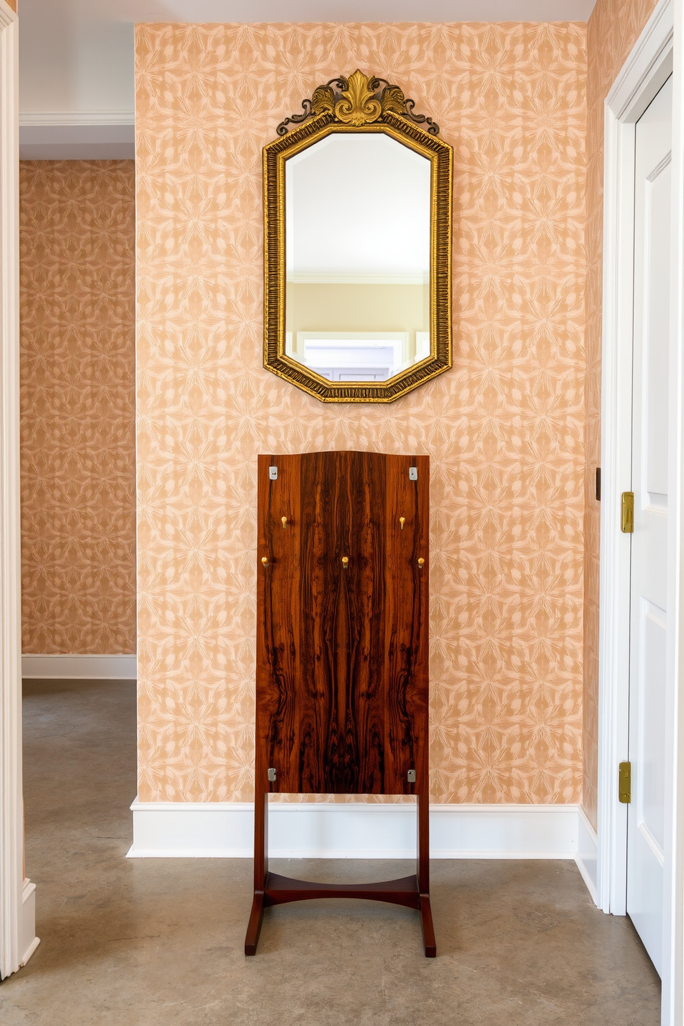 A vintage coat rack with a modern flair stands prominently in the foyer, crafted from rich walnut wood with sleek metal accents. The walls are adorned with geometric wallpaper in soft earth tones, complementing the warm hues of the coat rack. The flooring features polished concrete with a subtle sheen, providing a contemporary contrast to the vintage elements. A statement mirror with a brass frame hangs above a small console table, enhancing the space's elegance and functionality.