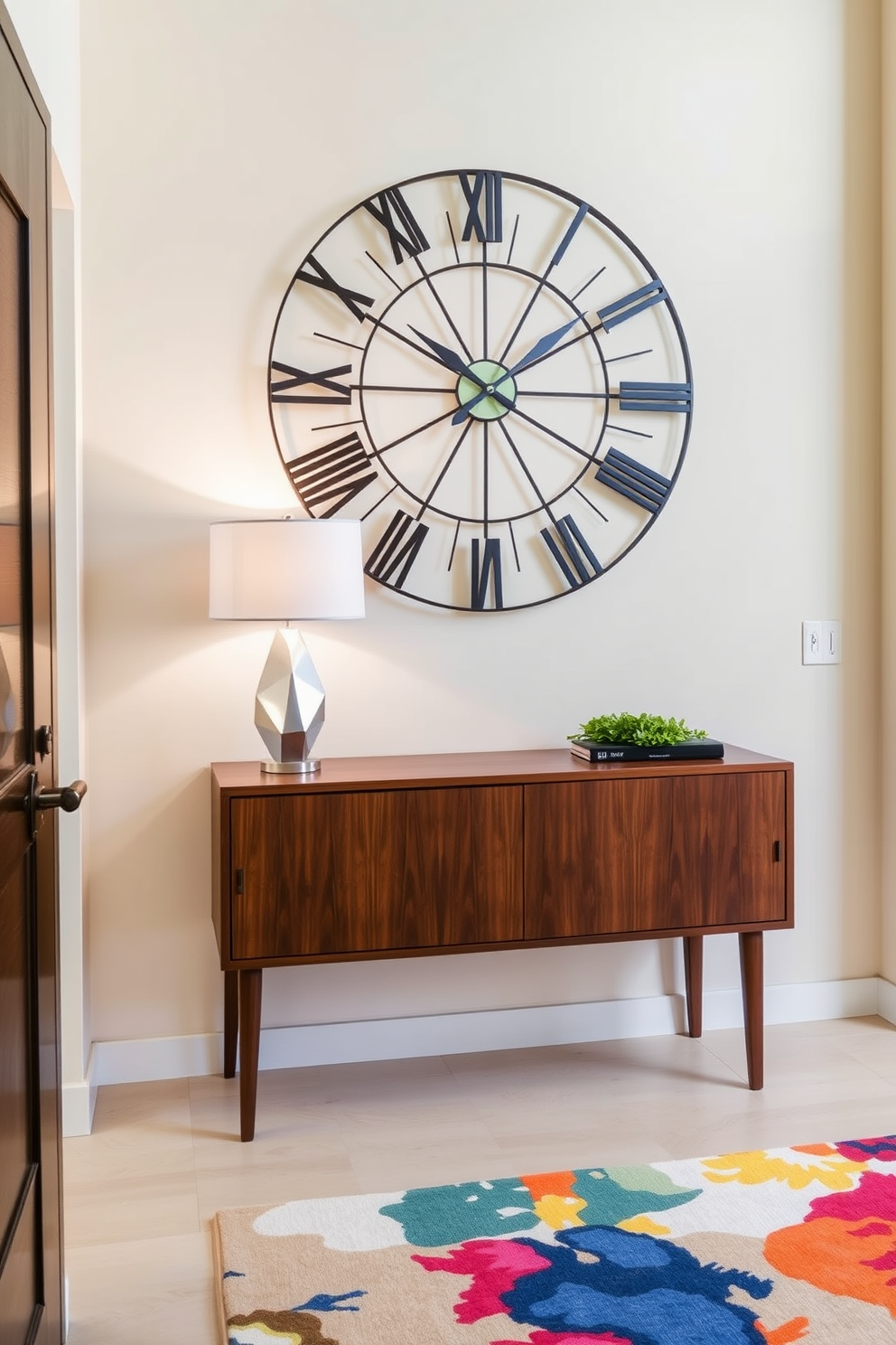 Artistic wall clock as a focal point. The foyer features a sleek console table with a rich walnut finish and a geometric lamp on top. The walls are painted in a soft cream color, providing a warm backdrop for the statement clock. A vibrant area rug with abstract patterns adds a pop of color to the space.