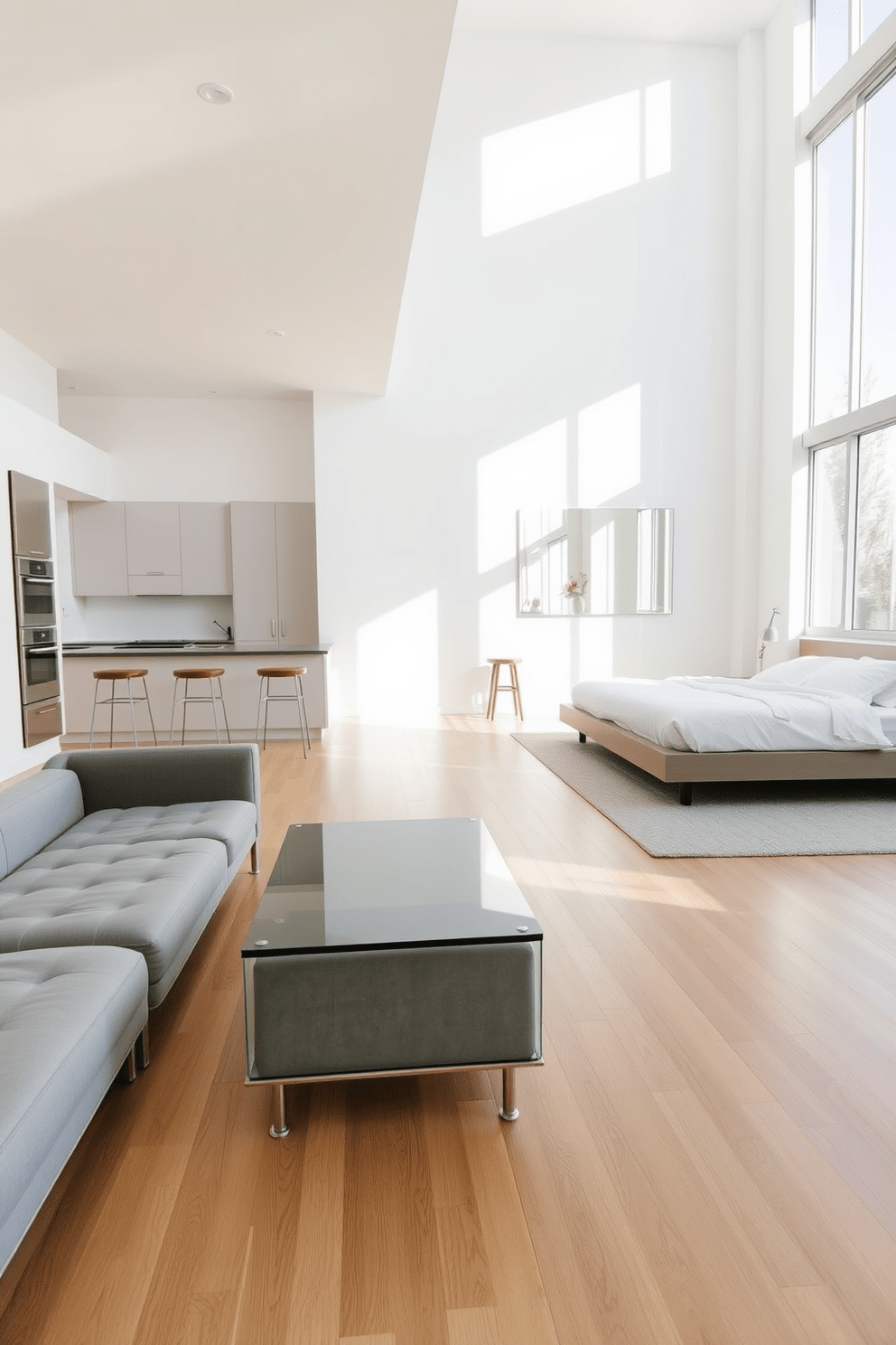 A minimalist apartment featuring an open layout with large windows that allow natural light to flood the space. The walls are painted in a soft white hue, and the flooring consists of light hardwood, creating a warm and inviting atmosphere. In the living area, a sleek gray sofa is paired with a glass coffee table, reflecting light and adding an airy feel. A large mirror is mounted on one wall, visually expanding the room and enhancing the brightness. The kitchen boasts minimalist cabinetry in a matte finish, complemented by stainless steel appliances. A simple island with bar stools serves as a functional space for dining and socializing. In the bedroom, a platform bed with crisp white linens is centered against a wall adorned with a large mirror. Soft lighting from bedside lamps creates a cozy ambiance, while a neutral rug adds warmth to the hardwood floor.