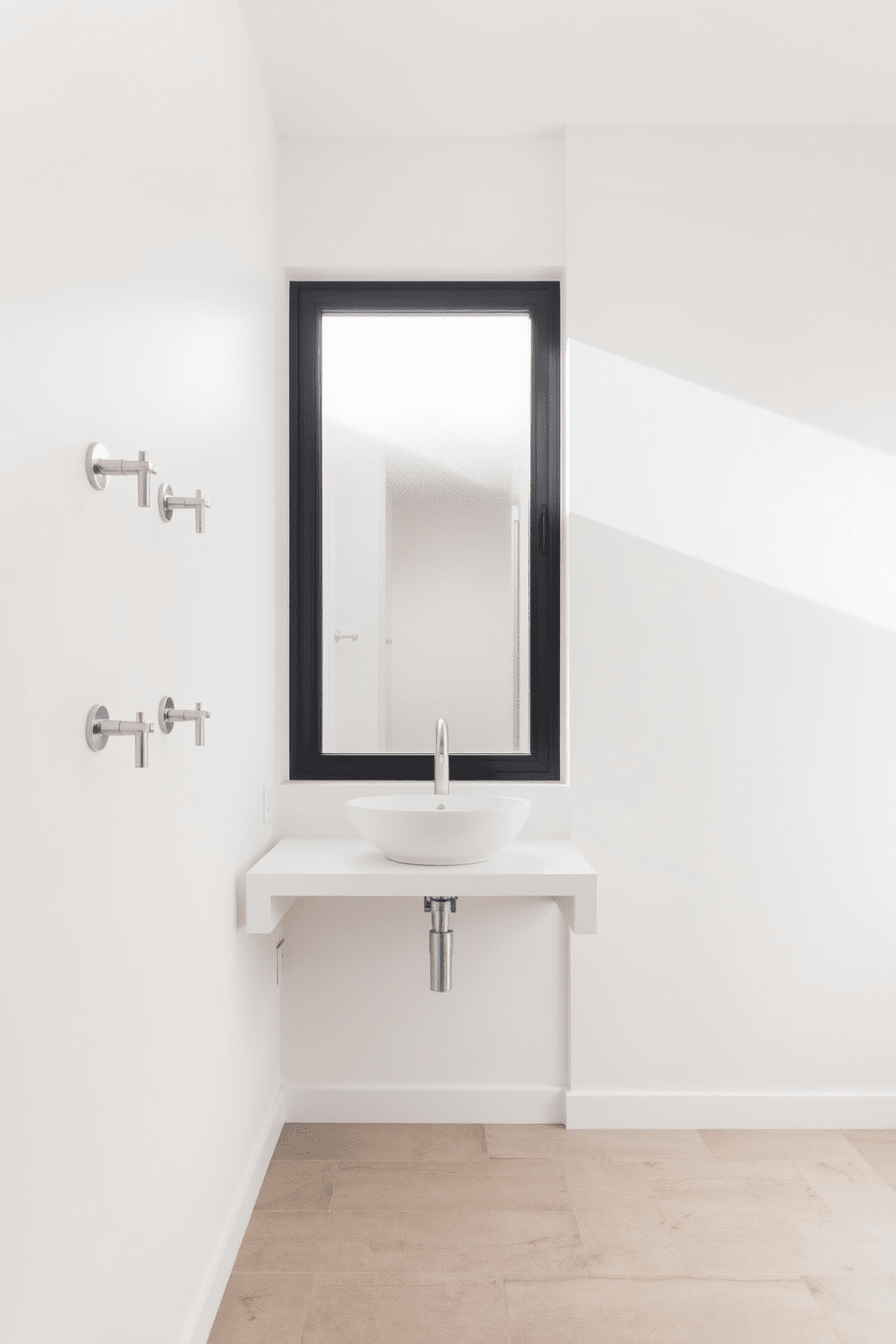 A minimalist bathroom design featuring wall-mounted faucets to maximize space. The walls are painted in a crisp white, creating a clean and airy atmosphere. A sleek floating vanity with a single basin sink is positioned beneath a large frameless mirror. Natural light streams in through a frosted window, illuminating the subtle textures of the neutral-toned tiles on the floor.