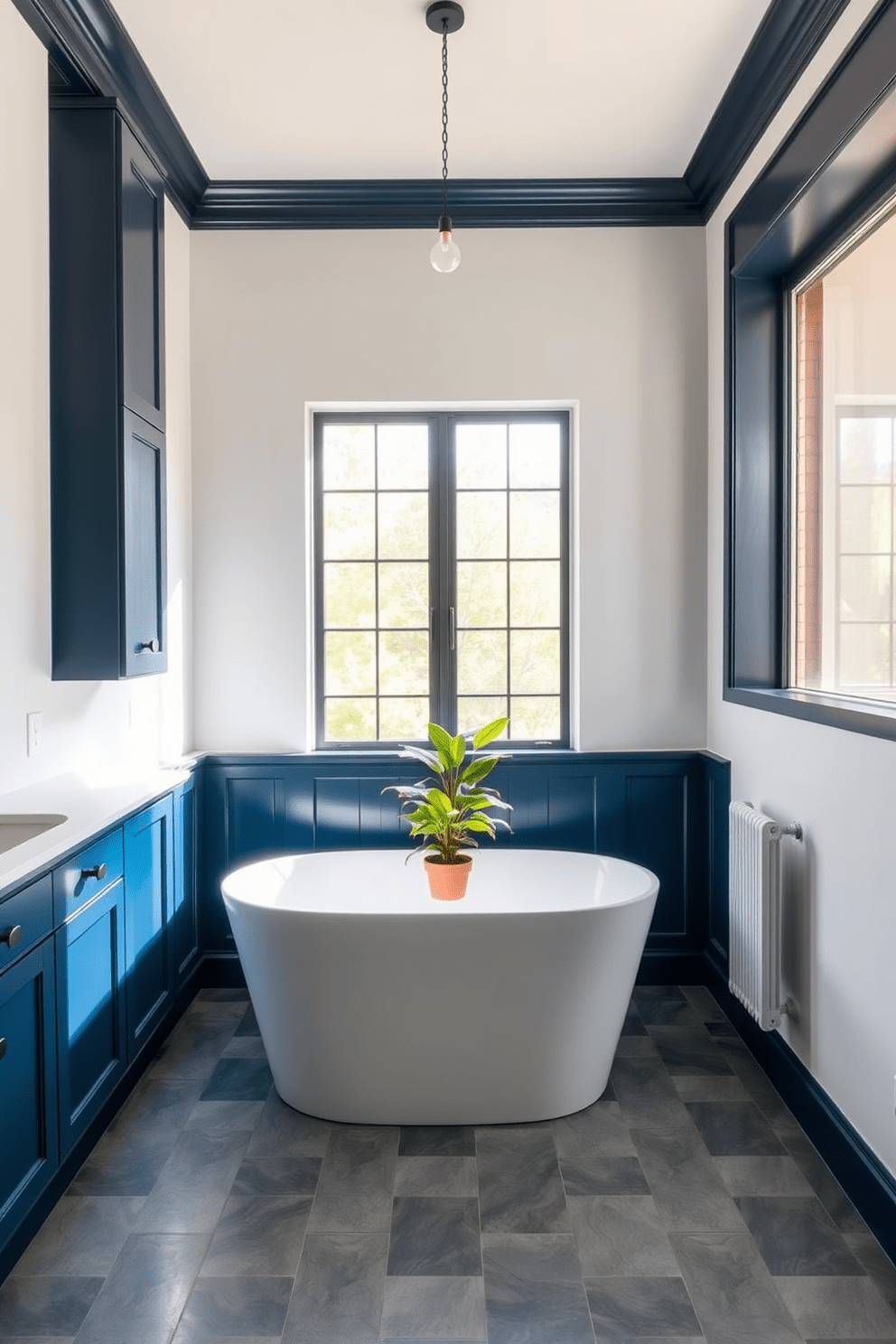 A minimalist bathroom featuring simple color-blocking for visual appeal. The walls are painted in a soft white hue, while the cabinetry showcases a bold navy blue finish. A freestanding tub sits in the center, surrounded by geometric tiles in varying shades of gray. Natural light floods the space through a large window, illuminating a potted plant placed on the edge of the tub.