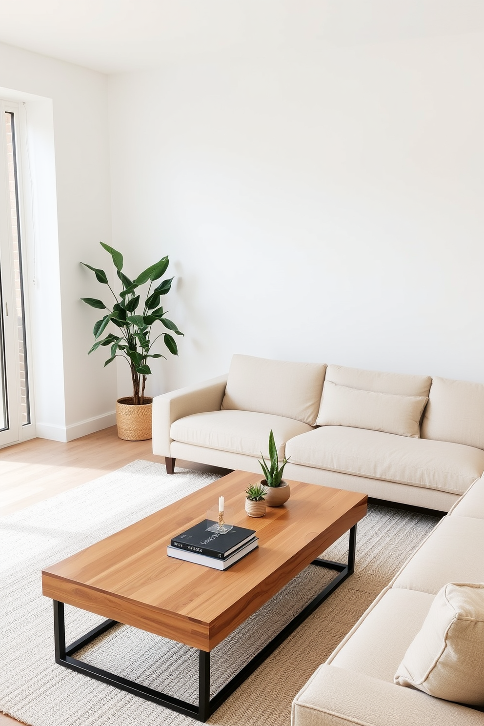 A minimalist family room featuring a soft beige sectional sofa with a low profile. A large potted plant stands in the corner, adding a touch of greenery to the space. The walls are painted in a crisp white, enhancing the room's airy feel. A simple wooden coffee table sits in the center, topped with a few decorative books and a small succulent.