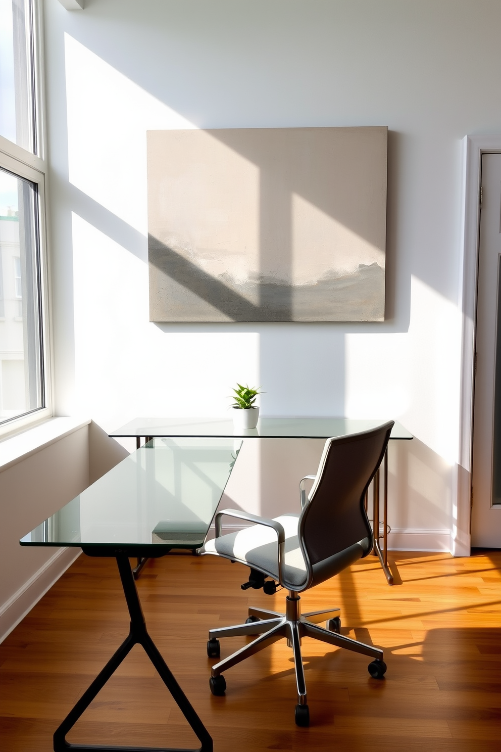 A minimalist home office featuring a sleek glass desk positioned against a soft white wall. A large abstract painting in muted tones serves as the statement piece above the desk, drawing attention and adding character to the space. The office chair is a modern ergonomic design in a light gray fabric, complementing the clean lines of the desk. Natural light floods the room through a large window, illuminating a small potted plant on the desk for a touch of greenery.