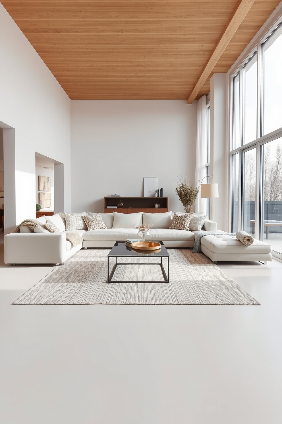 A minimalist living room features a soft neutral color palette with a large, comfortable sofa adorned with textured neutral-toned throws. The space is accented by a sleek coffee table and a few carefully chosen decorative elements, creating an inviting yet uncluttered atmosphere. Floor-to-ceiling windows allow natural light to flood the room, enhancing the airy feel. A simple area rug anchors the seating area, adding warmth without overwhelming the design.