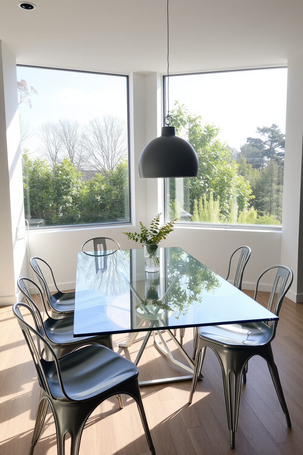 A sleek glass dining table is surrounded by stylish metal chairs, creating a contemporary and inviting atmosphere. The room features large windows that allow natural light to flood in, highlighting the clean lines and minimalist decor.