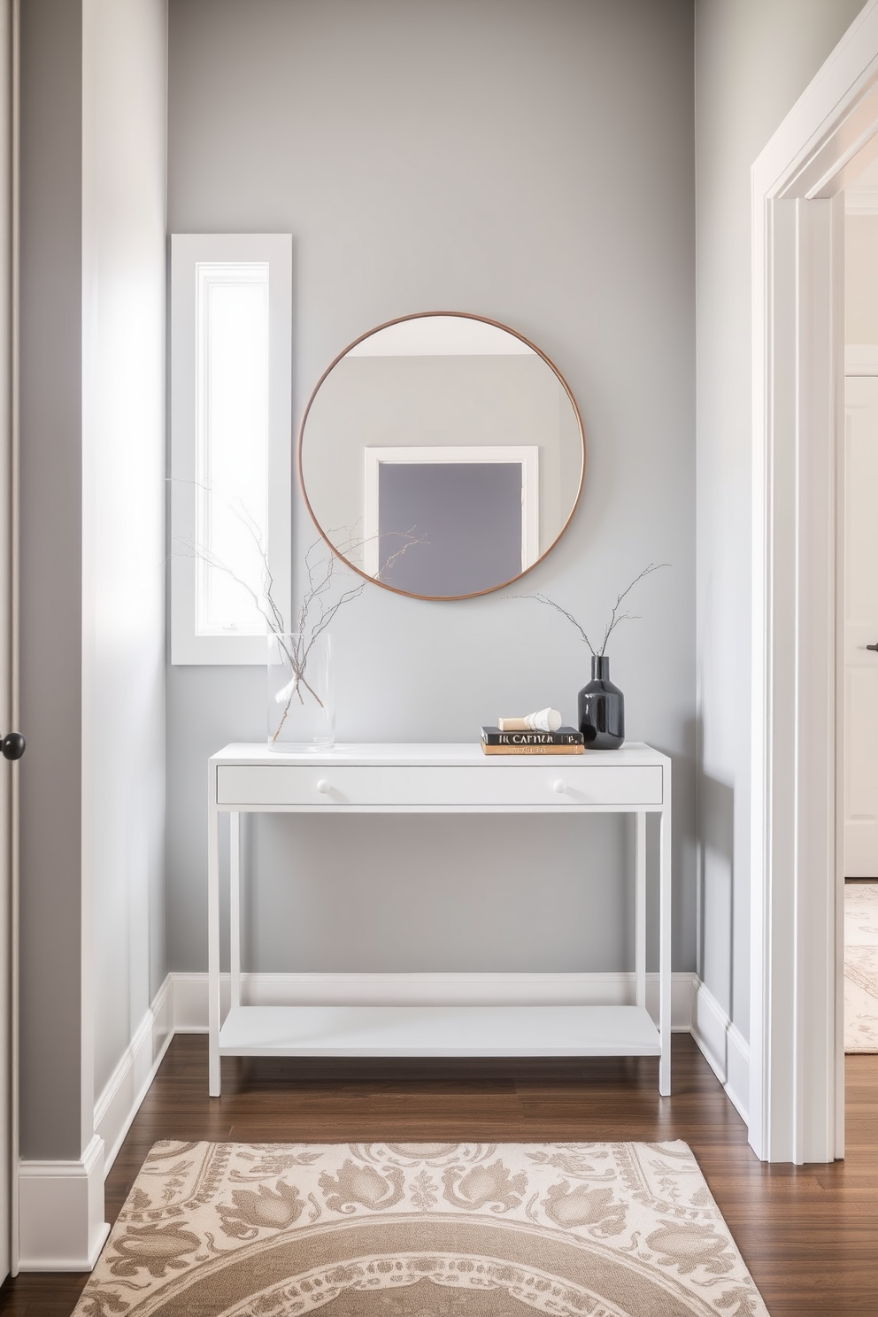 A modern entryway featuring a cohesive color scheme with soft gray walls and a sleek white console table. A large round mirror hangs above the table, reflecting natural light from a nearby window, while a stylish rug in muted tones adds warmth to the space.