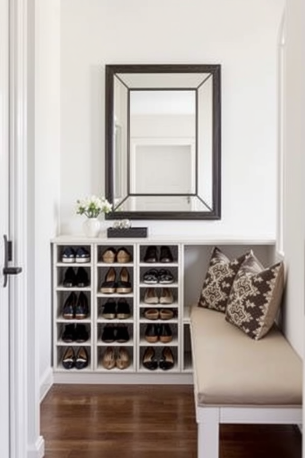 A modern entryway featuring functional shoe storage that blends seamlessly with the overall decor. The shoe storage unit is designed with clean lines and a sleek finish, providing ample space for various shoe styles while maintaining an organized look. The entryway is adorned with a statement mirror that enhances the sense of space and light. Complementing the shoe storage, a stylish bench offers a comfortable spot for putting on shoes, accented by decorative cushions for added comfort.