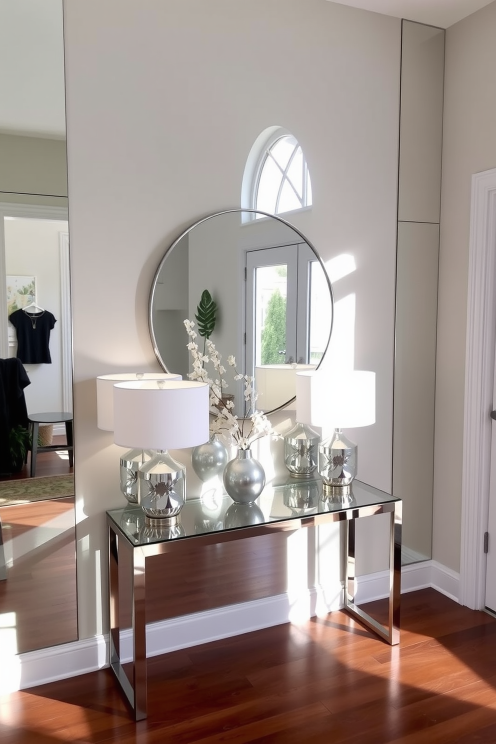 A modern entryway featuring mirrored accents that reflect natural light, creating an inviting atmosphere. The space includes a sleek console table with a glass top and a pair of stylish lamps, complemented by a large round mirror above the table.