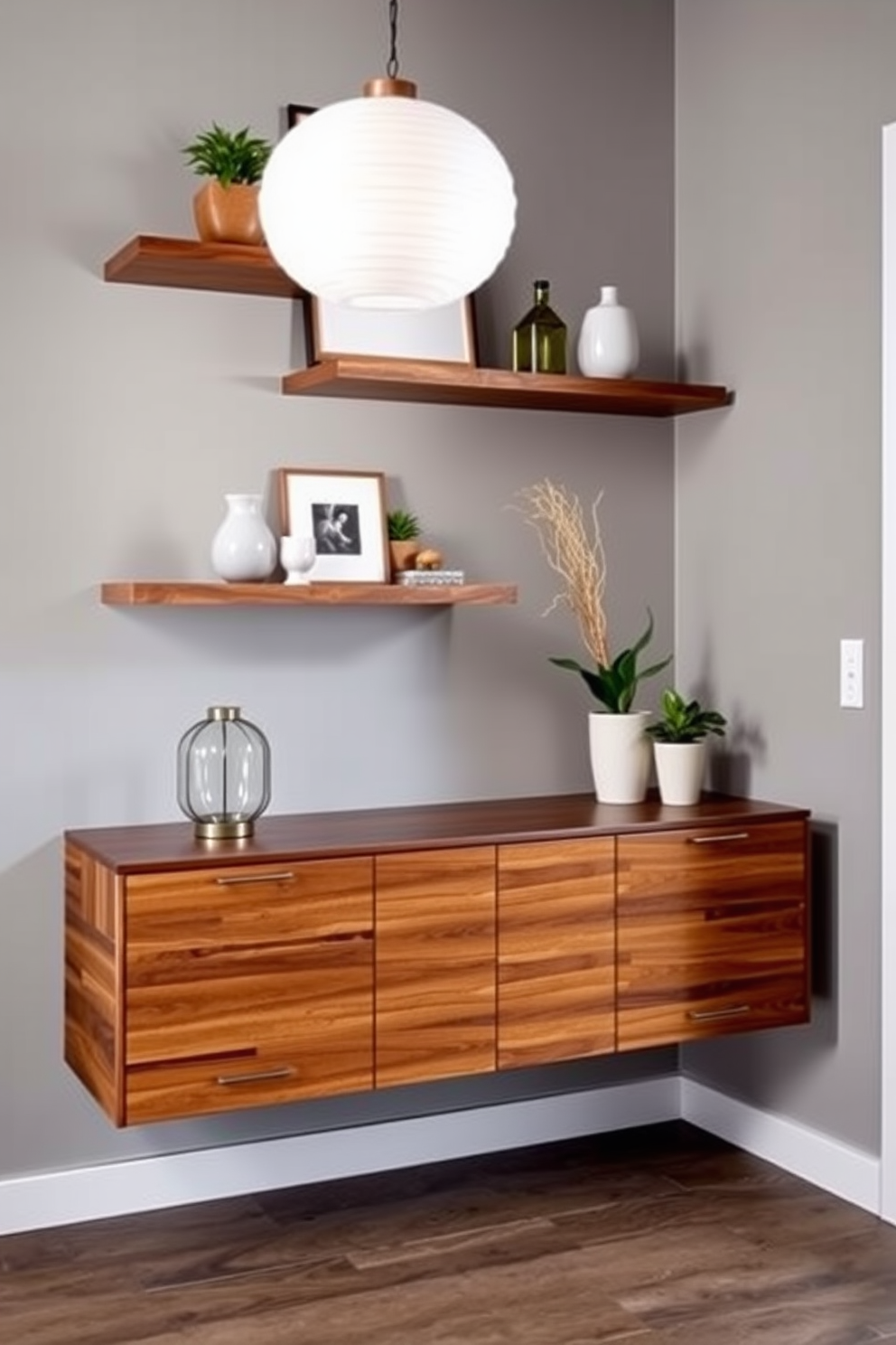 A modern entryway features floating shelves that elegantly display decorative items and plants. The walls are painted in a soft gray, complementing the warm wood tones of the shelves and the sleek console table below.