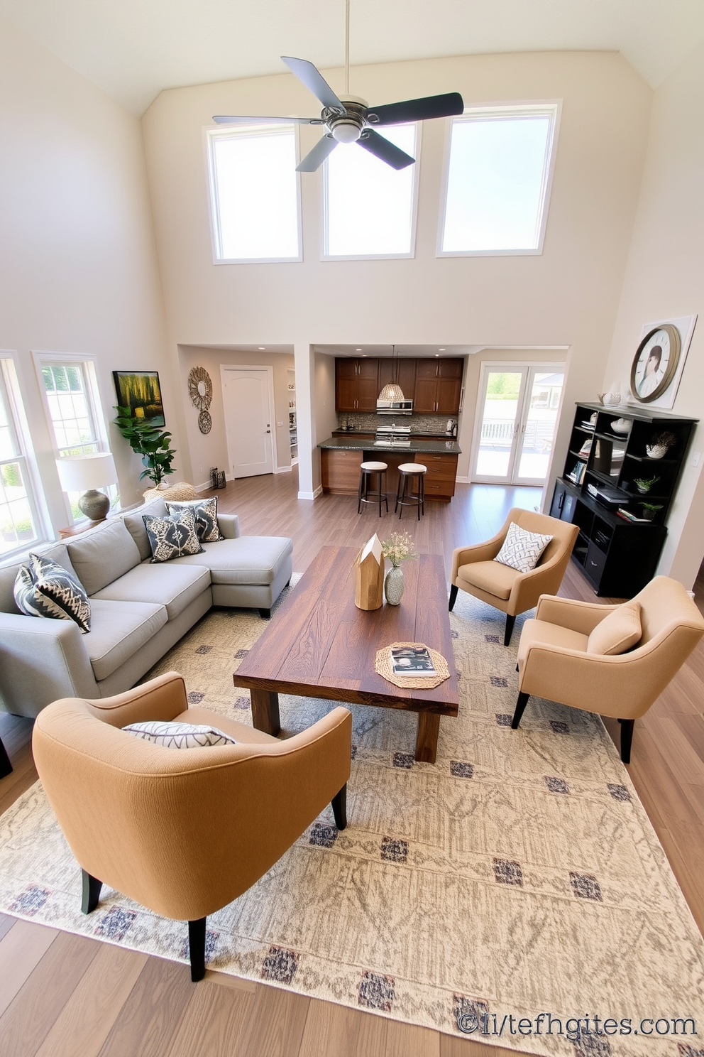 Open concept layout featuring a cozy seating area with a plush sectional sofa in soft gray fabric. A large coffee table made of reclaimed wood sits in the center, surrounded by accent chairs in warm earth tones. The walls are painted in a light beige hue, creating a warm and inviting atmosphere. Large windows let in natural light, and a stylish area rug adds texture and comfort to the space.