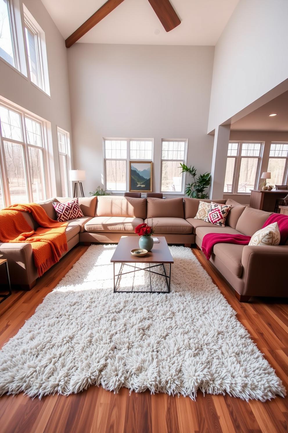 A modern family room featuring a cozy seating arrangement with a large sectional sofa adorned with colorful throw blankets for warmth. The room is filled with natural light from large windows, and a stylish coffee table sits in the center, complemented by a plush area rug.