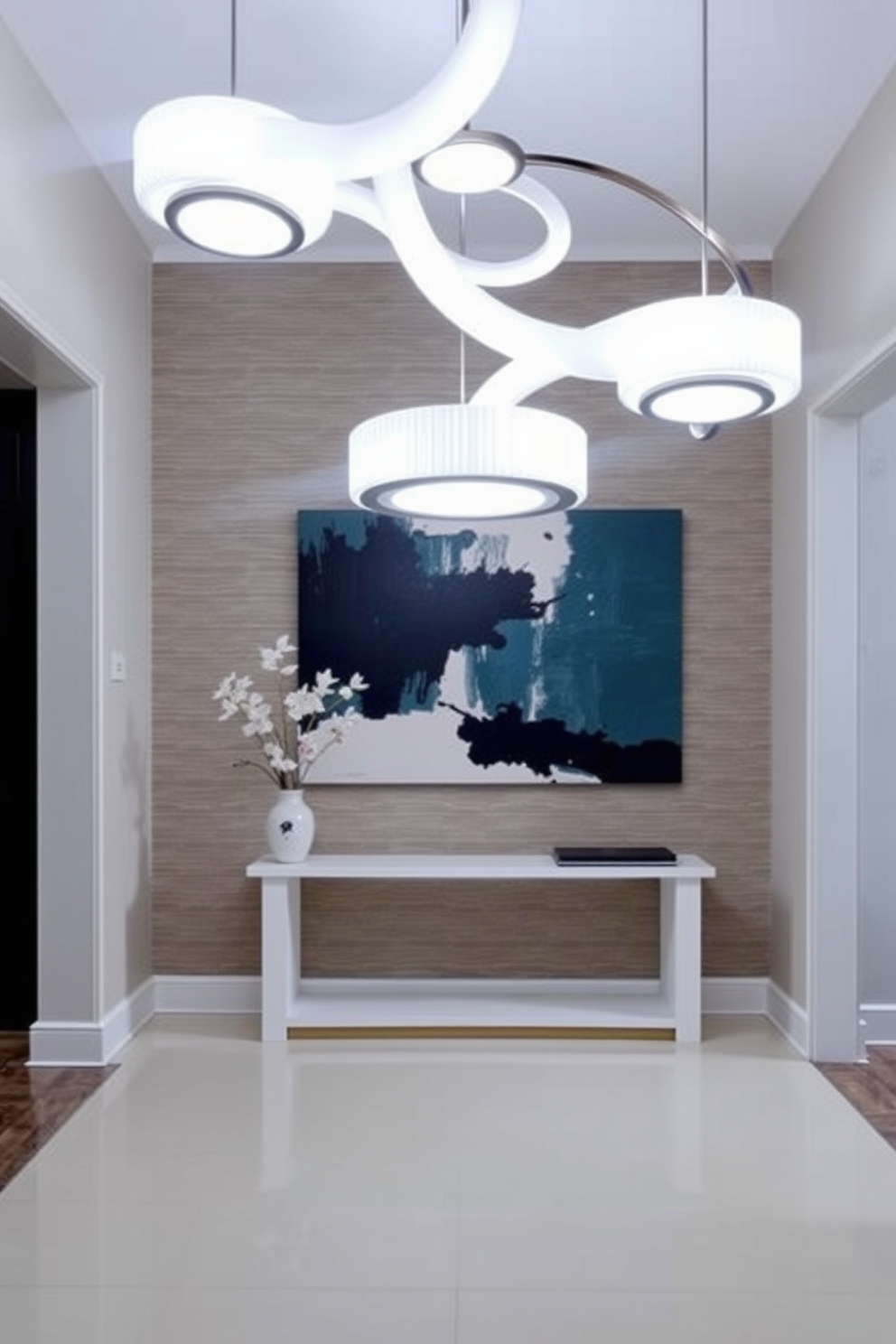 A modern foyer with sculptural lighting fixtures that serve as artistic focal points. The space features a sleek console table against a backdrop of textured wallpaper, with a large abstract painting above it.