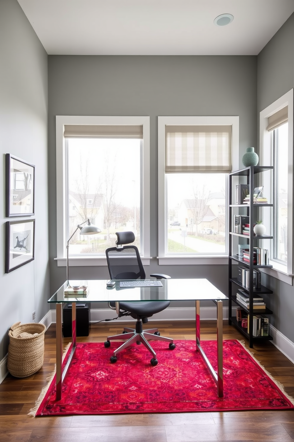 A modern home office with a sleek glass desk positioned against a wall adorned with framed artwork. A comfortable ergonomic chair is placed at the desk, while a stylish bookshelf filled with books and decorative items stands to the side. The color palette features soft grays and whites, complemented by a pop of color from a vibrant rug underfoot. Large windows allow natural light to flood the space, enhancing the inviting atmosphere and creating a productive environment.