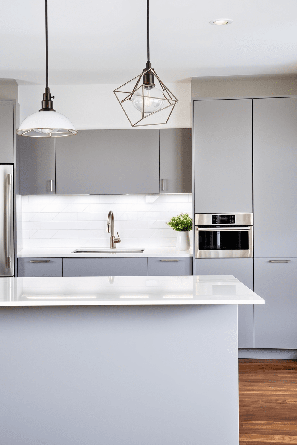 A modern kitchen design featuring crisp lines and angular shapes. The cabinetry is sleek and minimalist, with a matte finish in a soft gray tone, complemented by stainless steel appliances and geometric light fixtures. An island with sharp edges serves as the centerpiece, topped with a polished quartz surface. The backsplash consists of white subway tiles arranged in a herringbone pattern, enhancing the contemporary aesthetic.