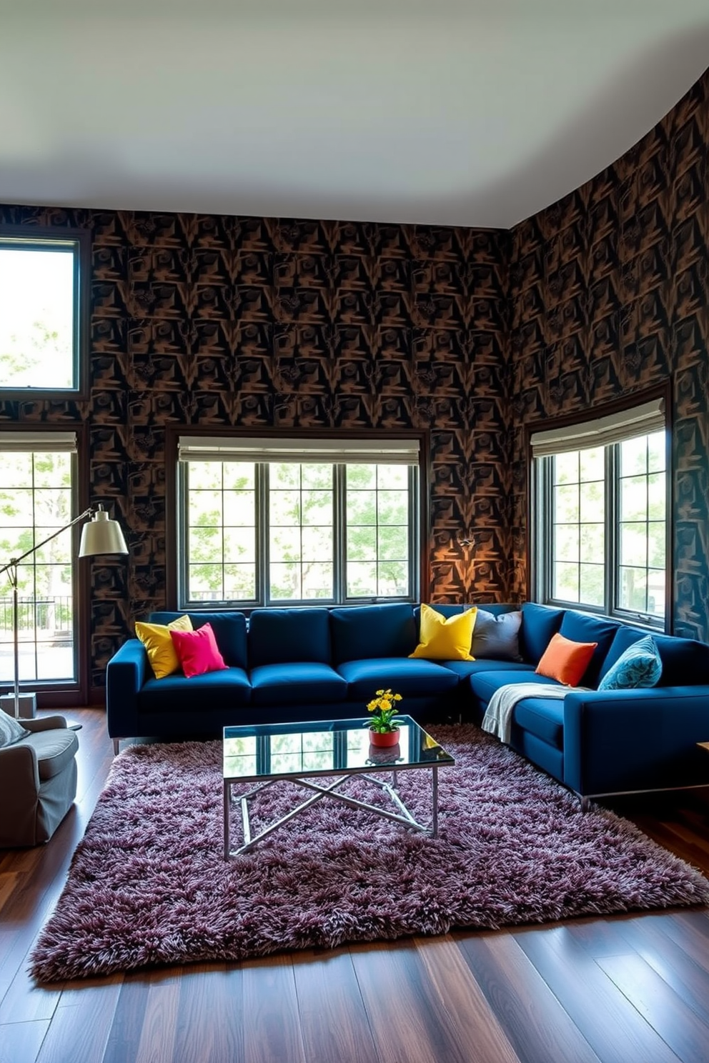 A modern living room featuring bold wallpaper with a striking geometric pattern that adds drama to the space. The room is furnished with a sleek sectional sofa in a deep navy blue, complemented by vibrant throw pillows and a stylish coffee table made of glass and metal. Large windows allow natural light to flood the room, highlighting the rich textures of a plush area rug beneath the seating area. A contemporary floor lamp stands in the corner, providing a warm glow that enhances the inviting atmosphere.