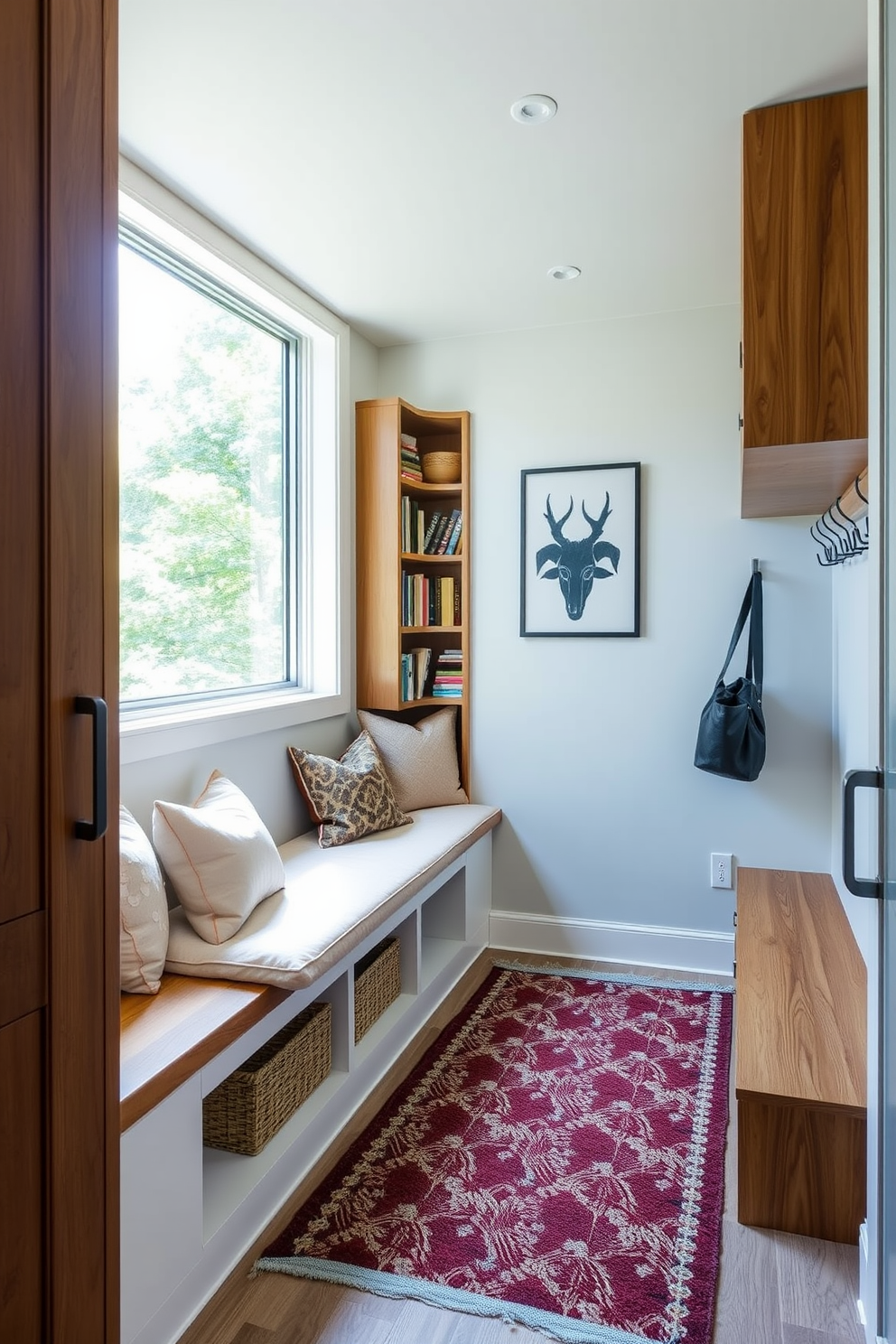 A modern mudroom design featuring a cozy reading nook. The space includes built-in benches with plush cushions and a bookshelf filled with an array of books. Natural light floods in through a large window, illuminating the warm wood tones of the cabinetry. A stylish area rug adds comfort underfoot, while hooks line the wall for easy access to coats and bags.